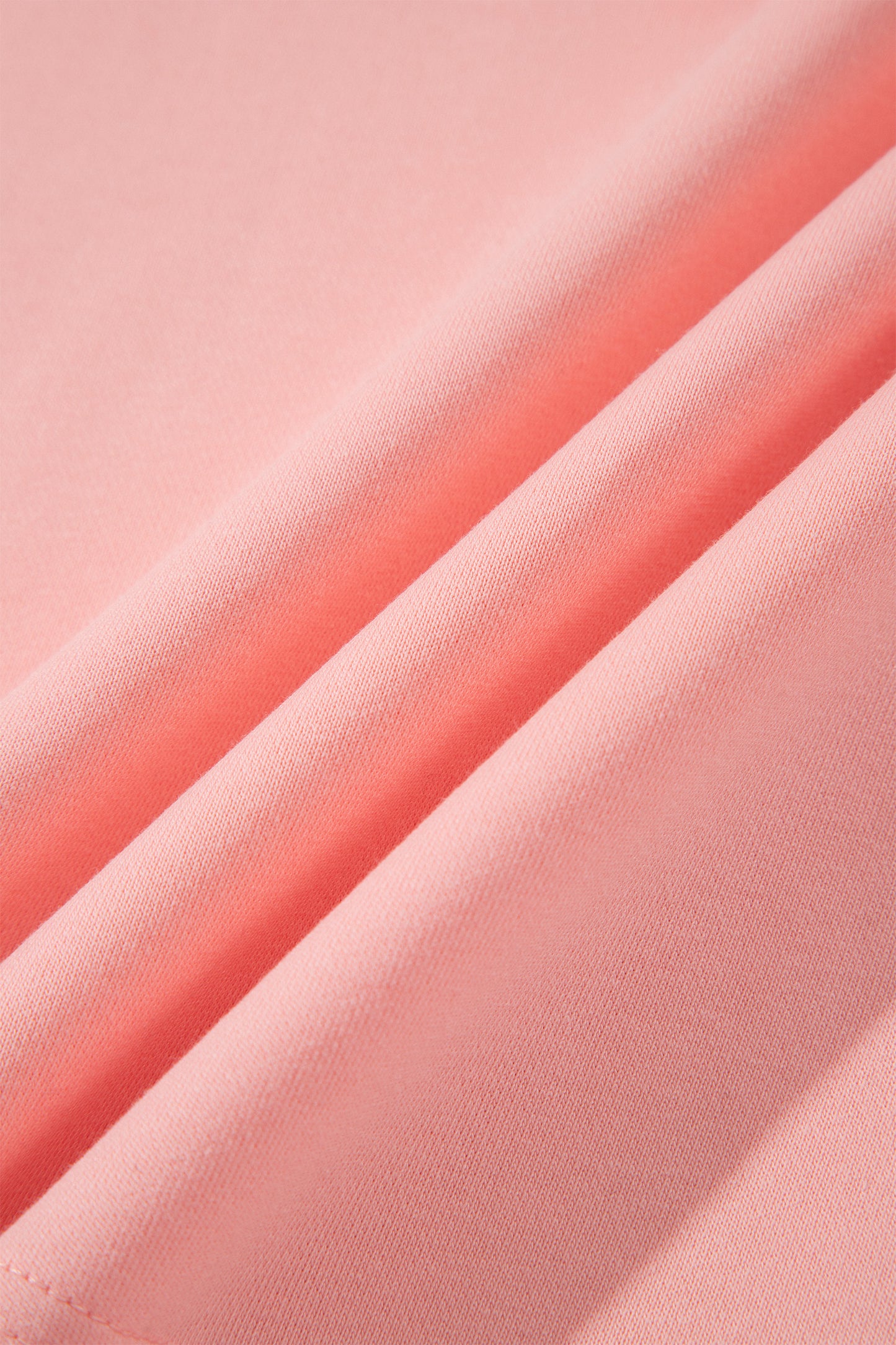 Pink crew neck long sleeve top with asymmetrical paneled body design and blue striped color block sleeves with contrasting orange accents.