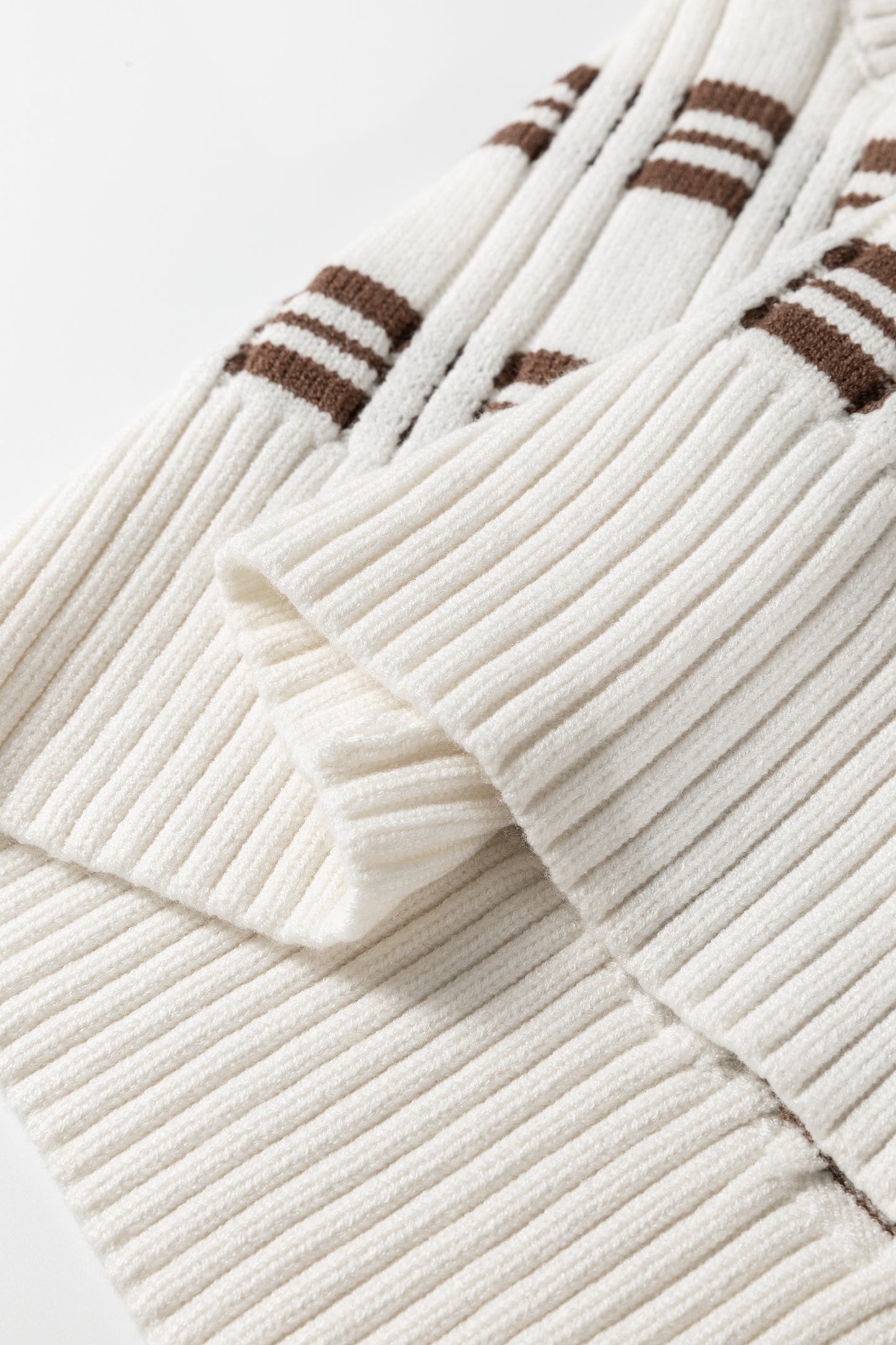 Oatmeal knit sweater vest with brown striped pattern, V-neckline, sleeveless design, and ribbed trim.