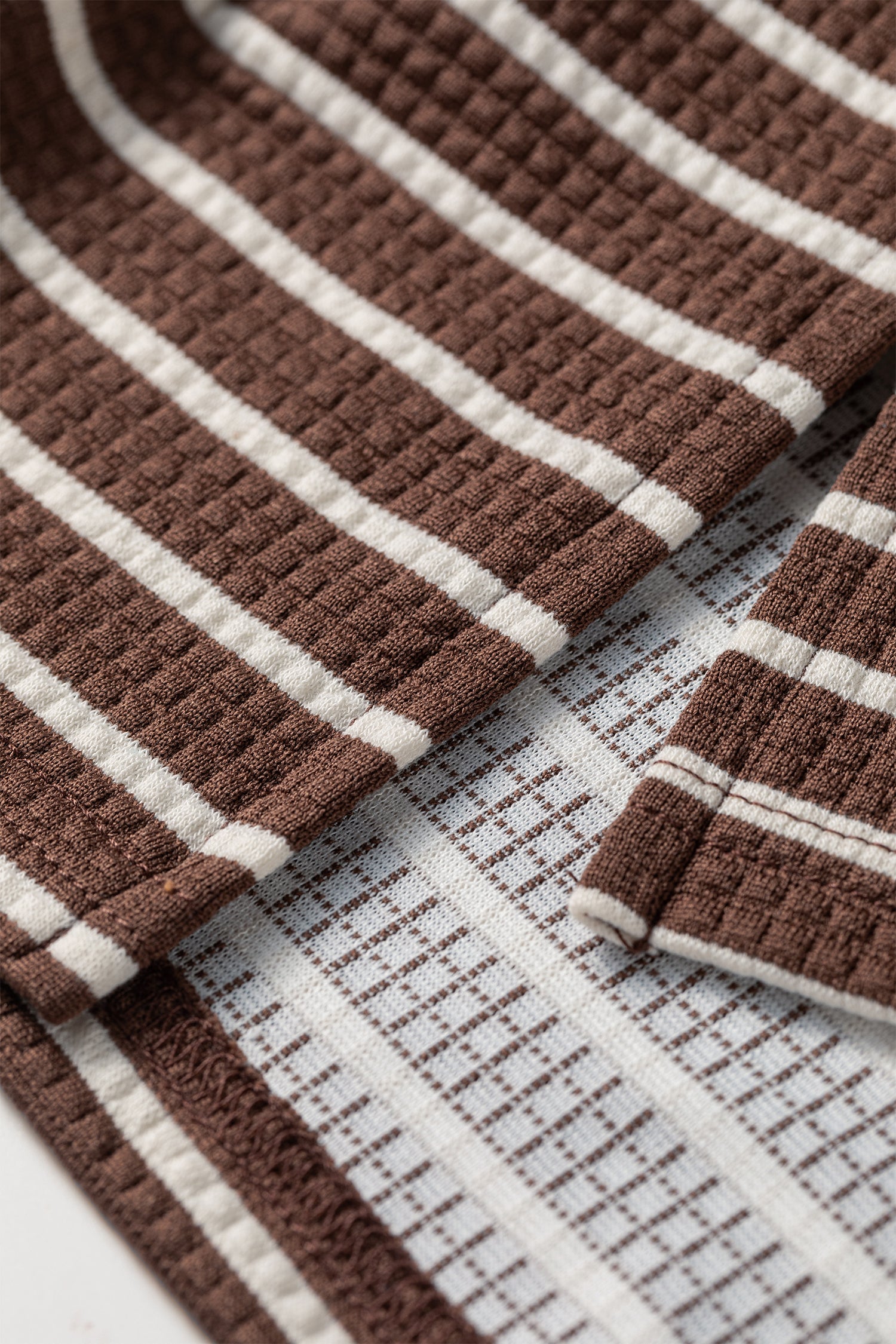 Cocoa Caramel and ivory striped colorblock pullover with a collared V-neckline, dropped shoulders, and long paneled sleeves.