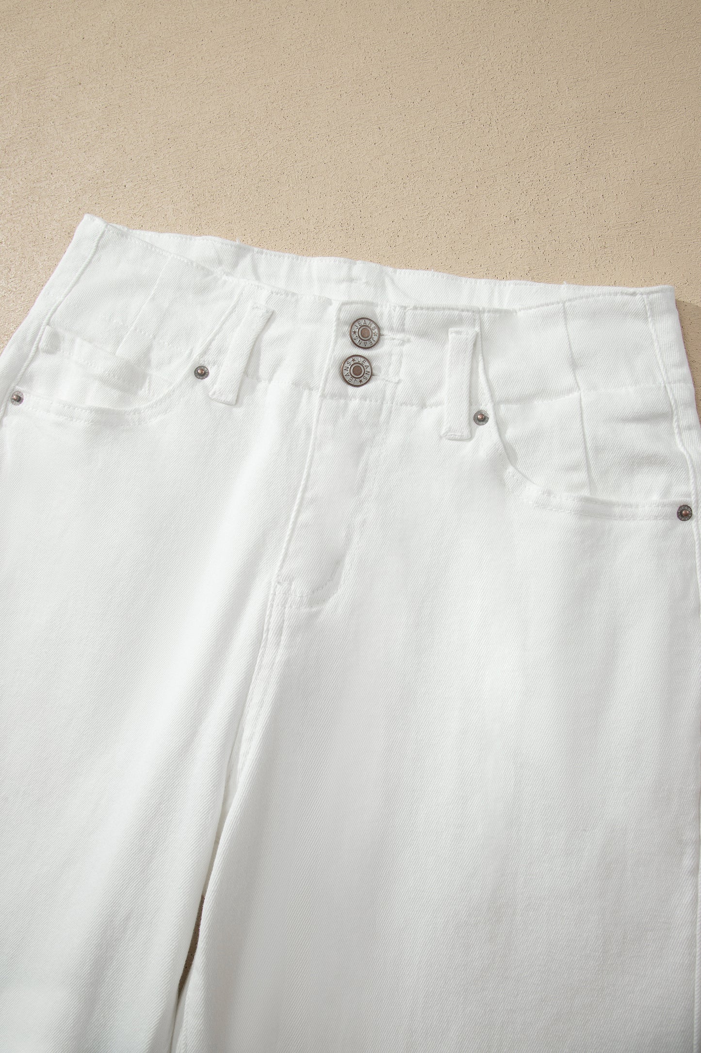 White high rise wide leg jeans with double-button waistband, front pockets and cropped hem.