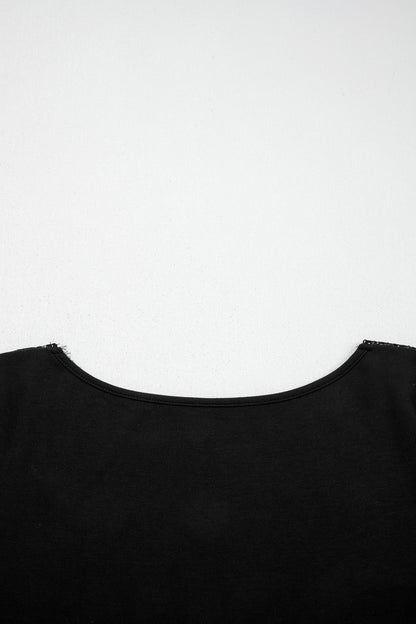 Black fitted long sleeve top with floral lace-trim V-neckline and soft stretch fabric styled with white pants.