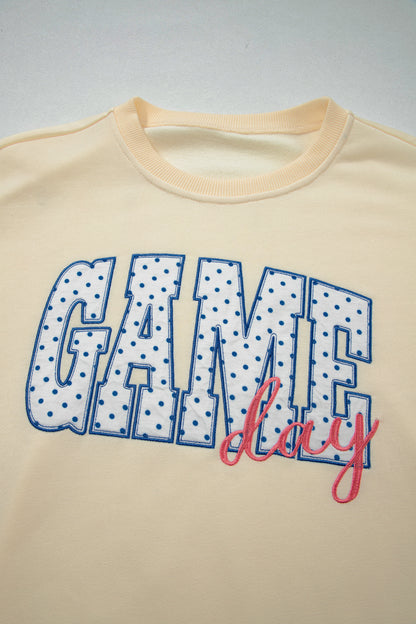 Cream Game Day embroidered sweatshirt and matching drawstring shorts set featuring long sleeves, blue contrast trim, relaxed fit, and casual sporty style.