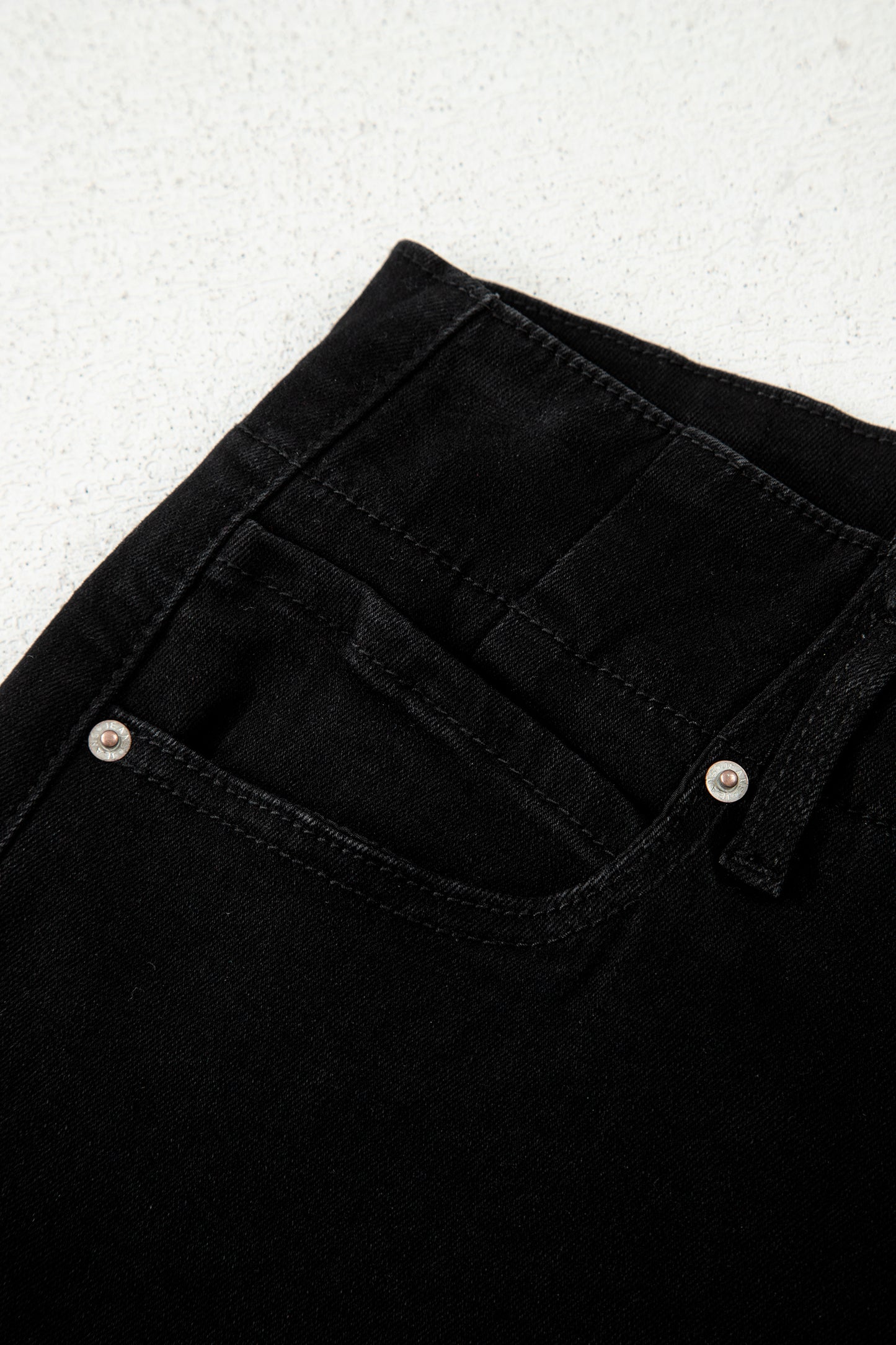 Black high rise wide leg jeans with double-button waistband, front pockets and cropped hem.