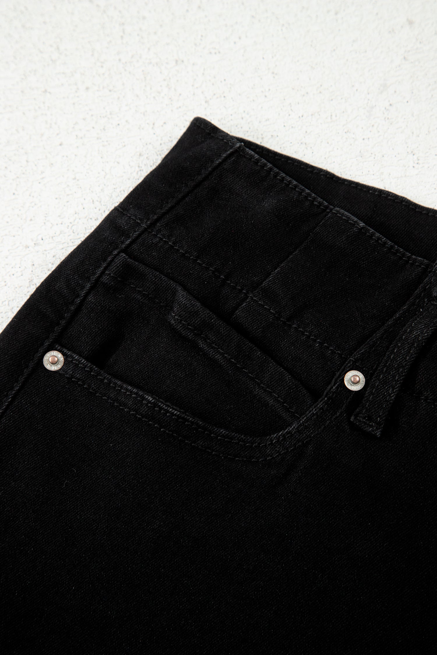 Black high rise wide leg jeans with double-button waistband, front pockets and cropped hem.