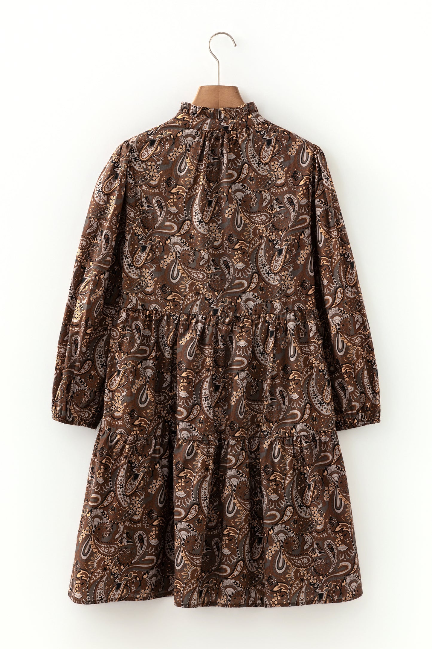 Mocha paisley babydoll mini dress with V-neckline, tie detail, long gathered sleeves, and relaxed tiered silhouette.