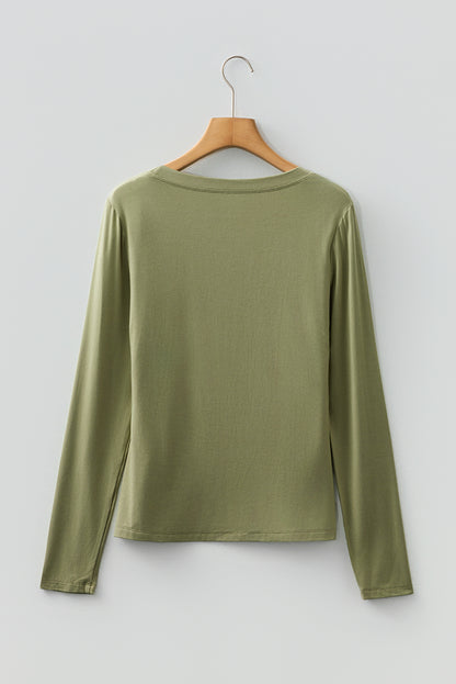 Woman wearing a Soft Sage scoop neck long sleeve top with a soft casual fit and white pants.