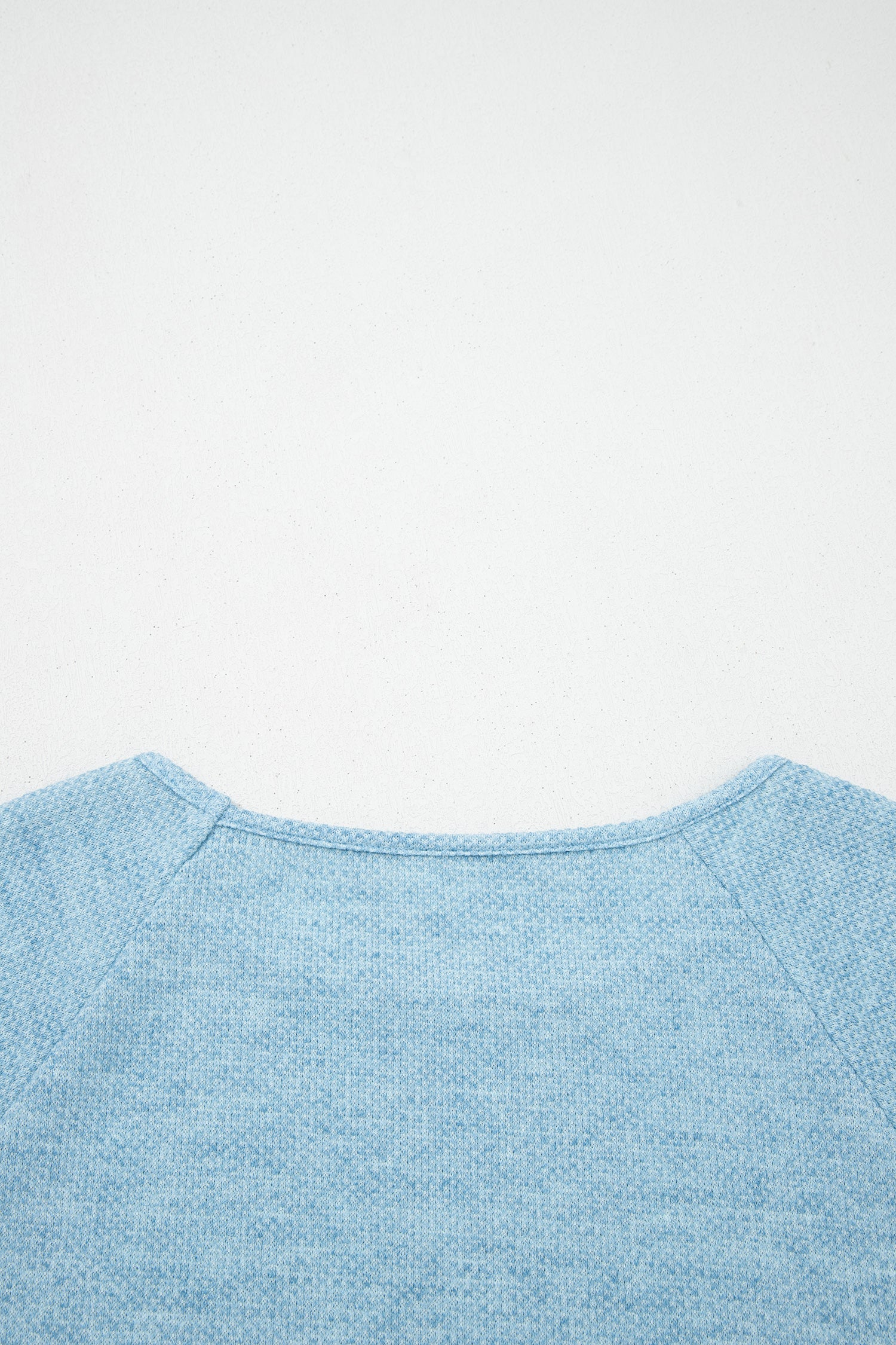 Powder Blue textured raglan long sleeve top with round neckline, relaxed fit, and curved hem