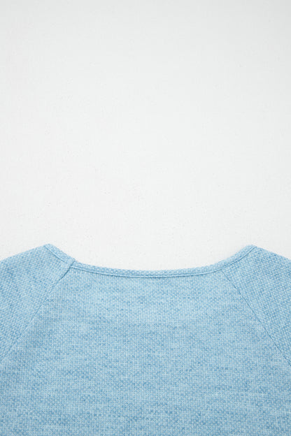 Powder Blue textured raglan long sleeve top with round neckline, relaxed fit, and curved hem