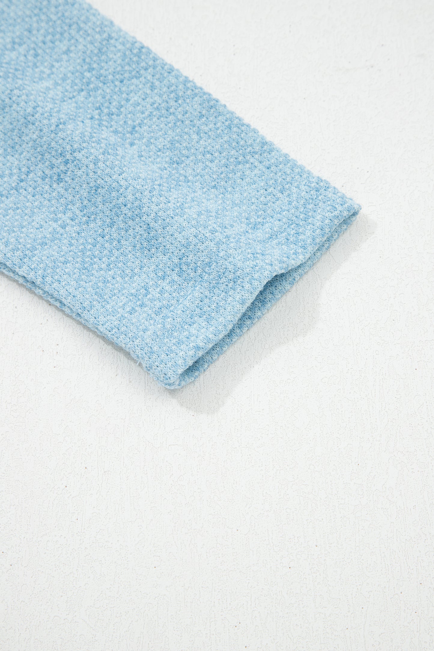 Powder Blue textured raglan long sleeve top with round neckline, relaxed fit, and curved hem