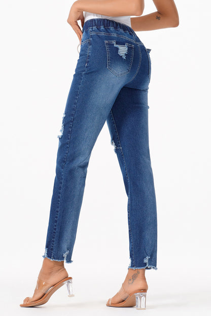 Medium wash blue distressed slim straight leg jeans with drawstring elastic waist and raw hem