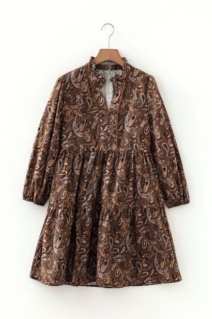 Mocha paisley babydoll mini dress with V-neckline, tie detail, long gathered sleeves, and relaxed tiered silhouette.