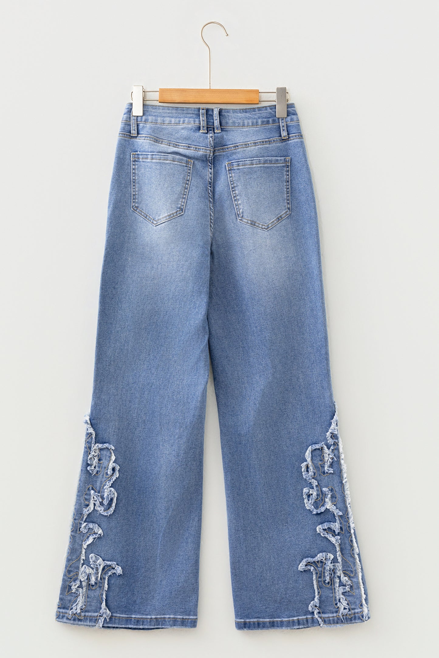 Light Wash Blue high rise Western flare jeans with embroidered lower-leg detailing and full-length wide leg silhouette.