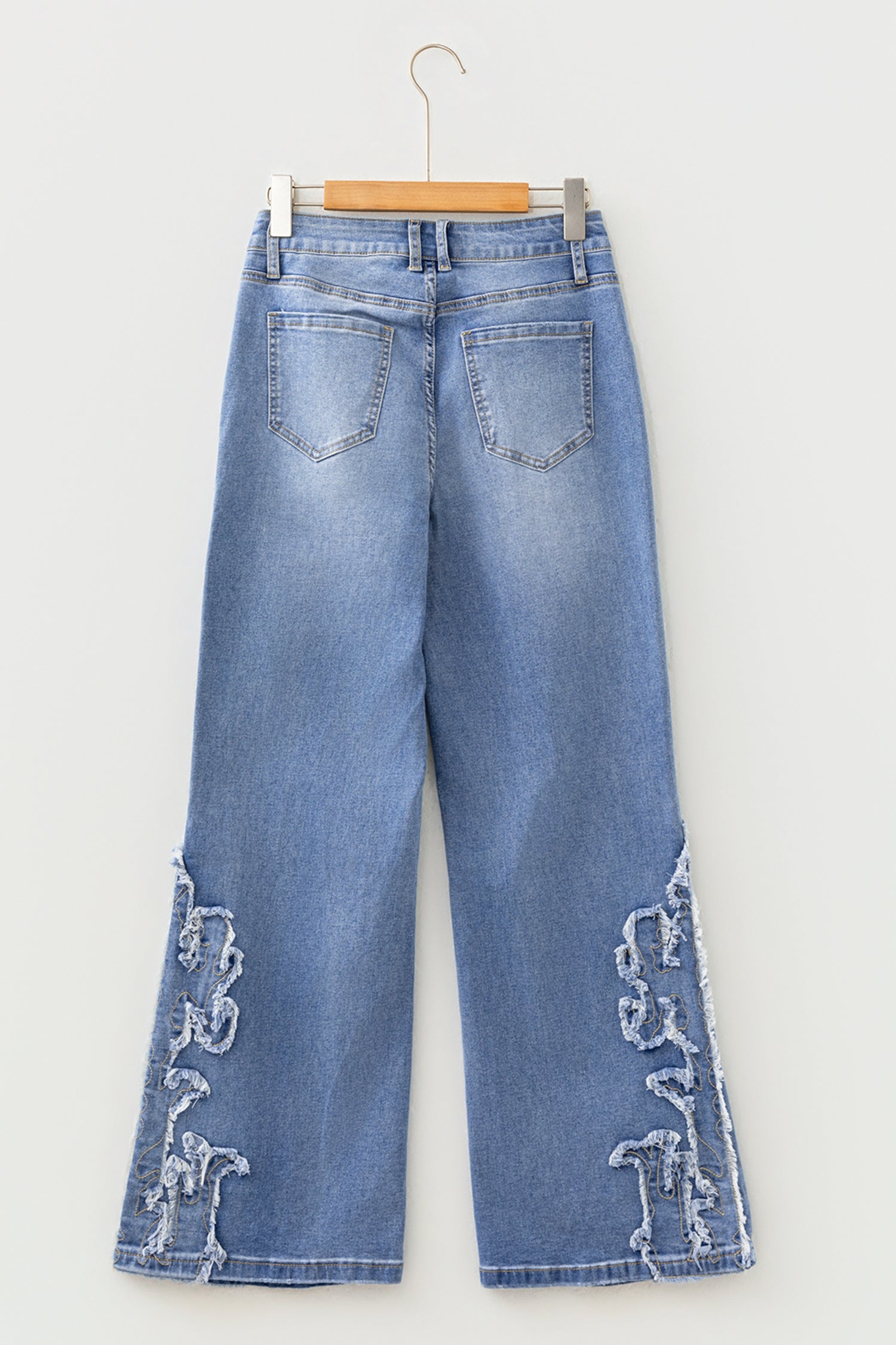 Light Wash Blue high rise Western flare jeans with embroidered lower-leg detailing and full-length wide leg silhouette.