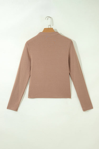 Warm taupe fitted high neck long sleeve top with a smooth stretch-knit finish and regular-length hem.