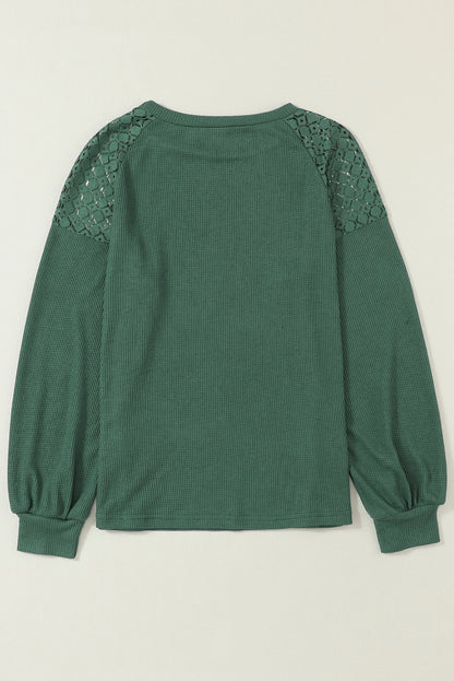Forest green waffle knit long sleeve top with floral lace shoulder panels, crew neckline, relaxed fit, and balloon sleeves.