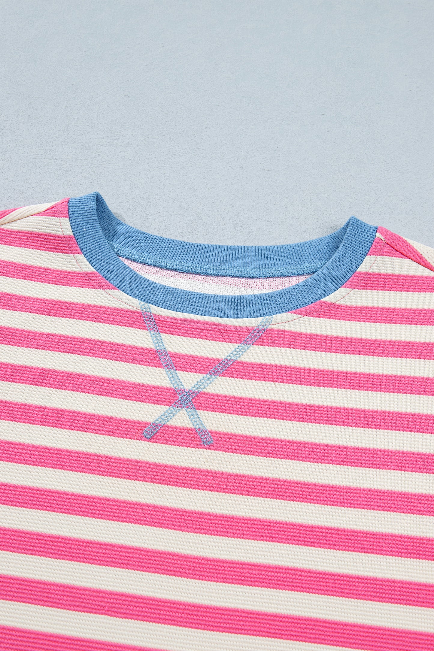 Pink and white textured striped knit short sleeve top with blue contrast ribbed neckline and sleeve cuffs, relaxed fit, and crew neckline.
