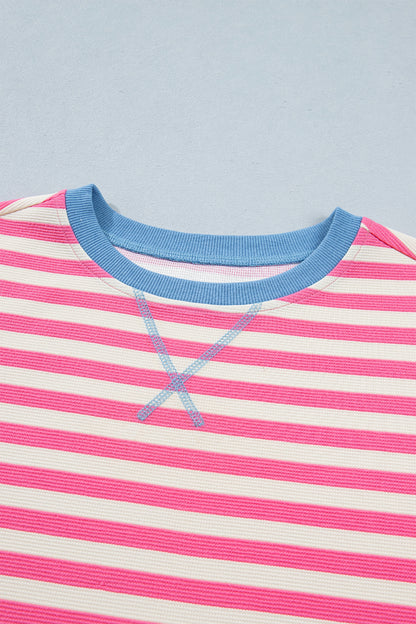 Pink and white textured striped knit short sleeve top with blue contrast ribbed neckline and sleeve cuffs, relaxed fit, and crew neckline.