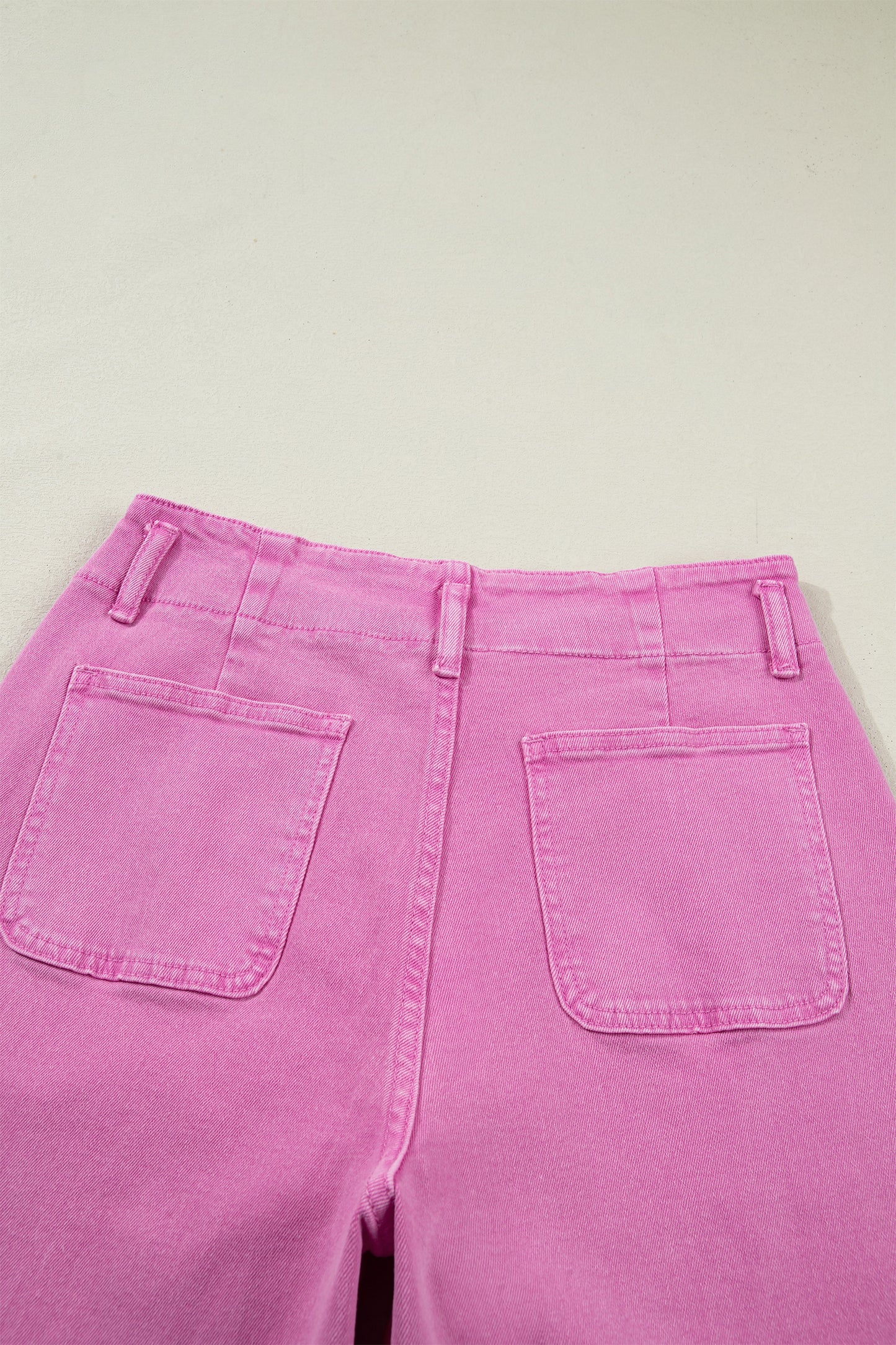 Pink high rise wide leg jeans with double-button waistband, front pockets and cropped hem.