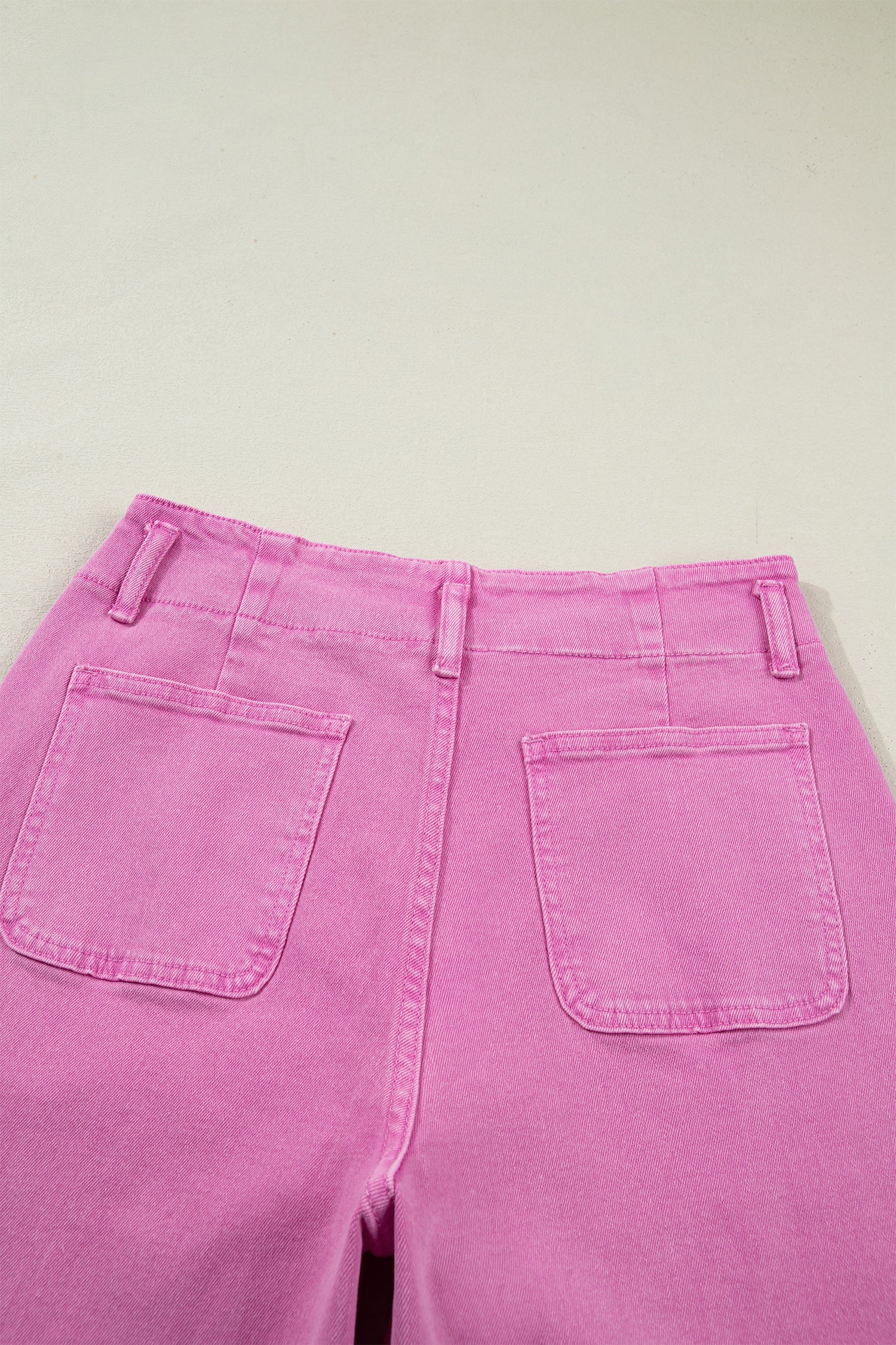 Pink high rise wide leg jeans with double-button waistband, front pockets and cropped hem.