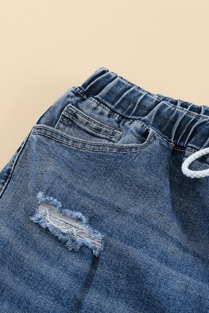 Medium wash blue distressed slim straight leg jeans with drawstring elastic waist and raw hem
