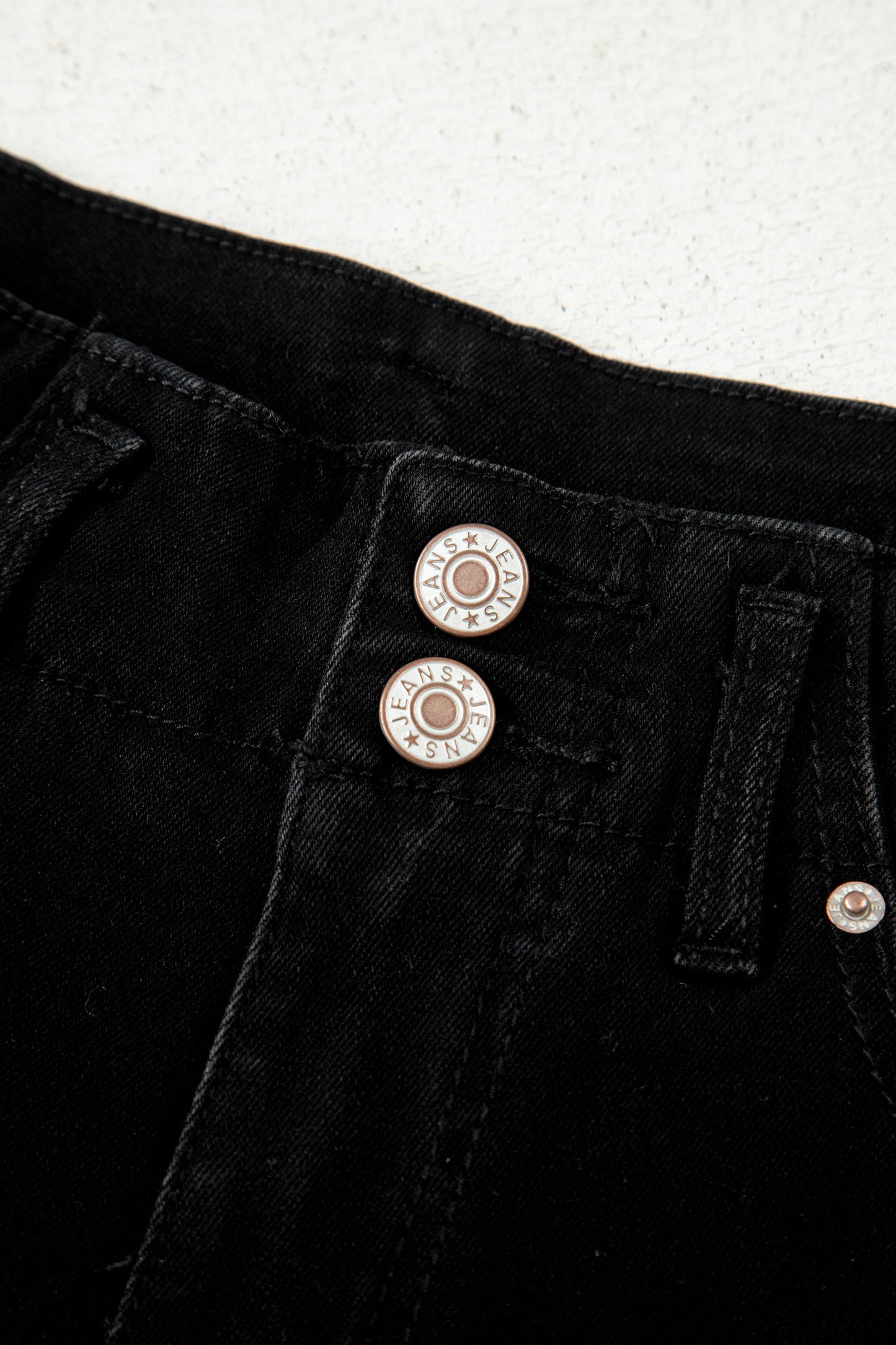 Black high rise wide leg jeans with double-button waistband, front pockets and cropped hem.
