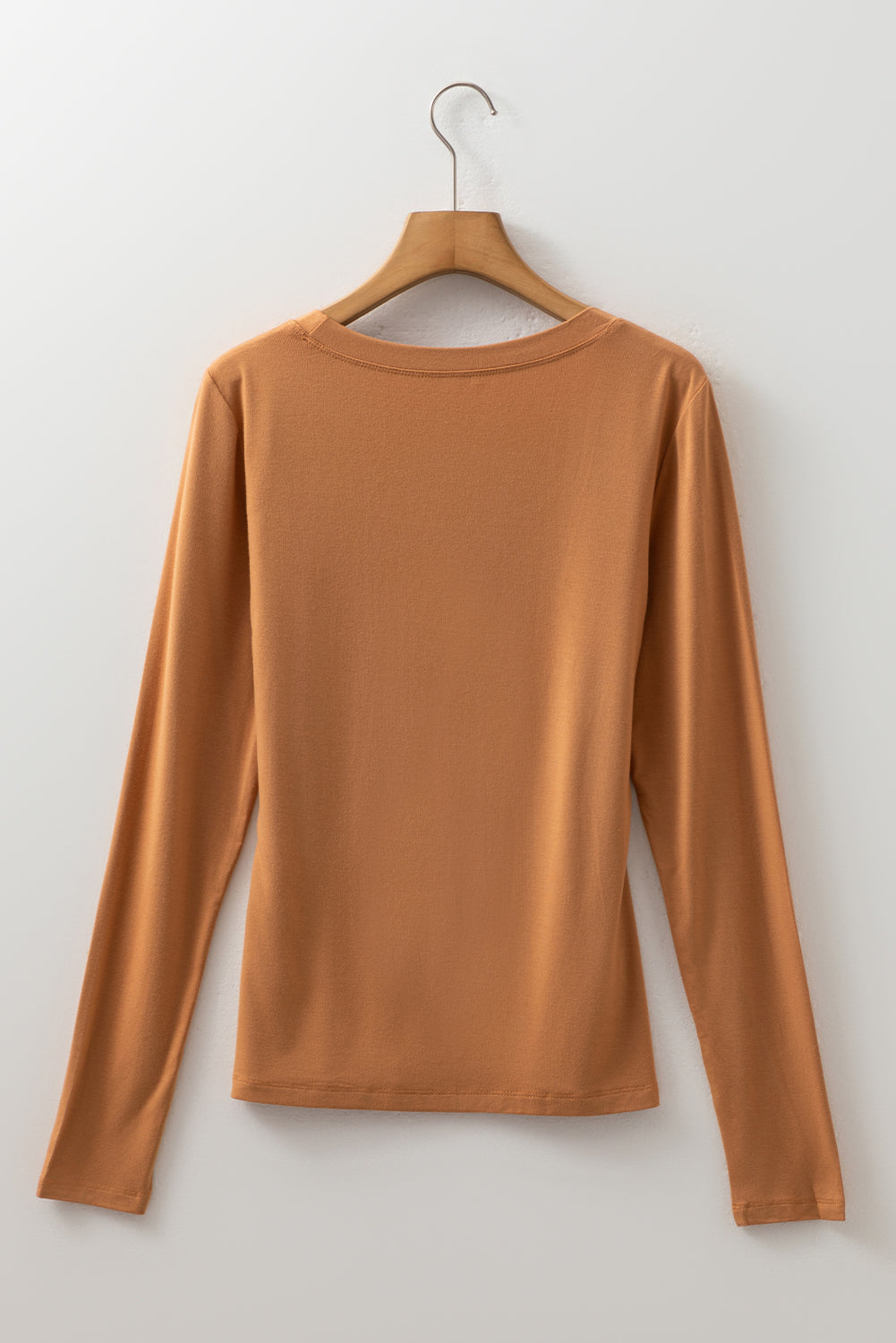 Woman wearing a Caramel Mocha scoop neck long sleeve top with a soft casual fit and white pants.