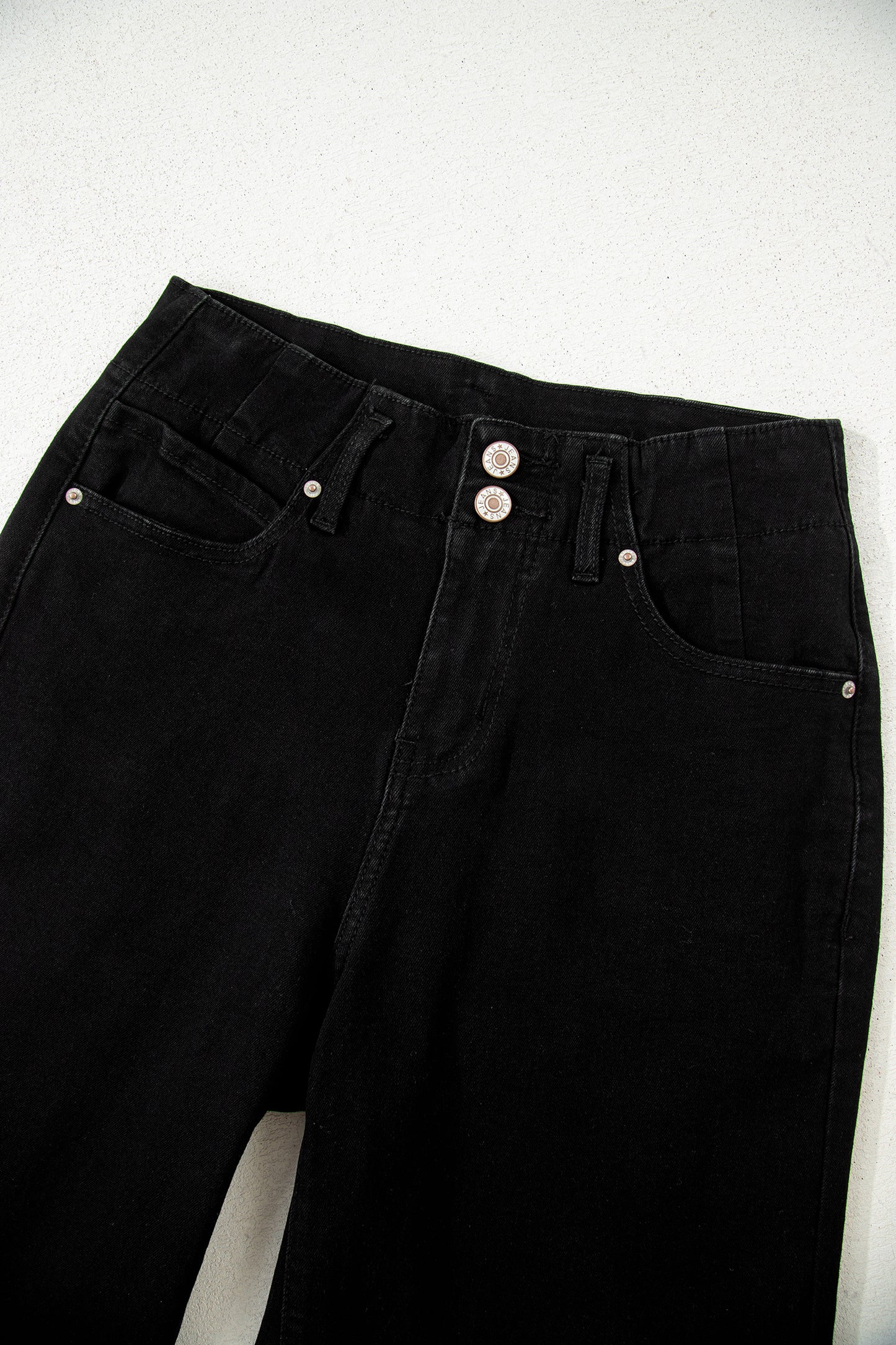 Black high rise wide leg jeans with double-button waistband, front pockets and cropped hem.