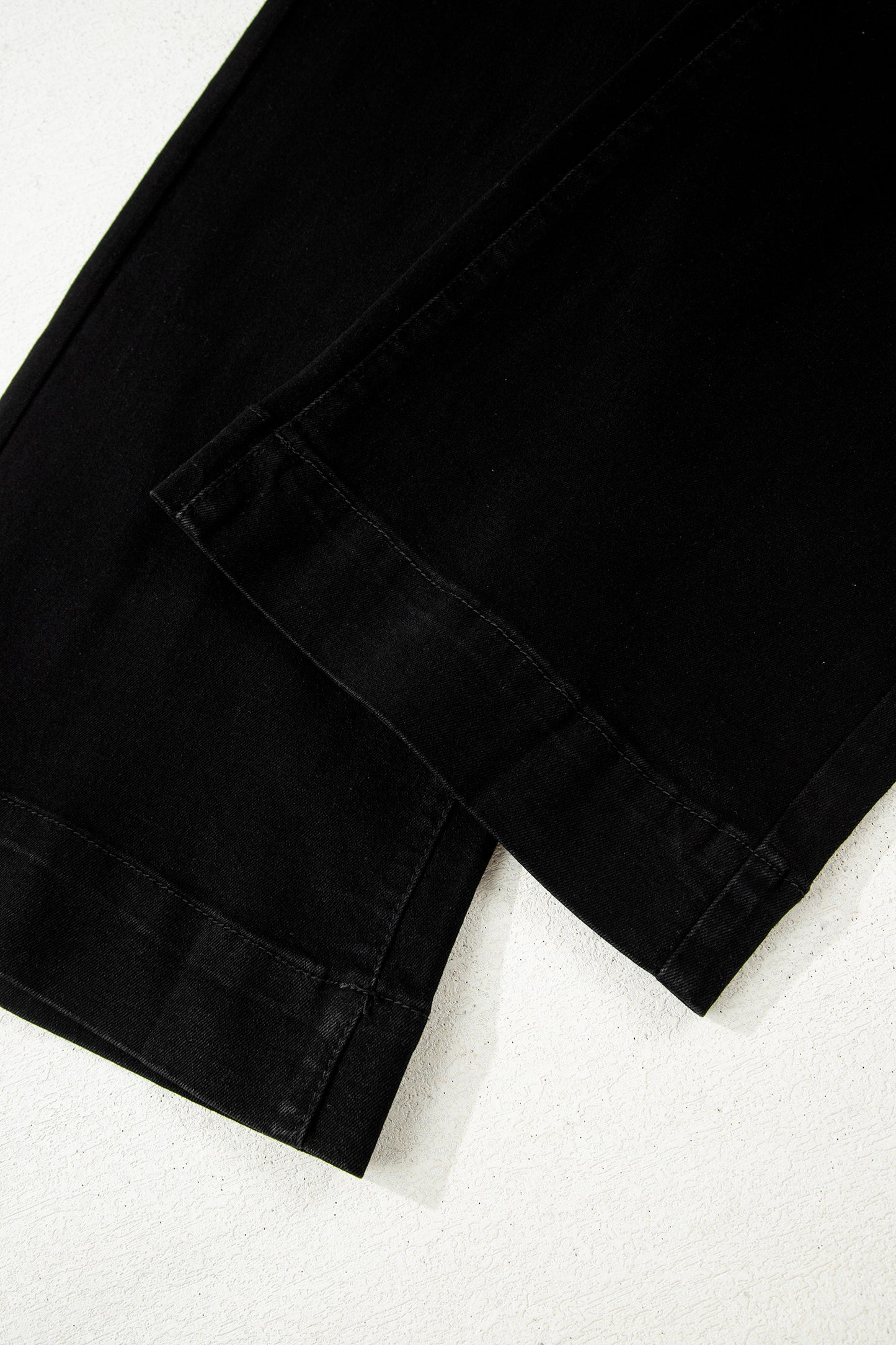Black high rise wide leg jeans with double-button waistband, front pockets and cropped hem.