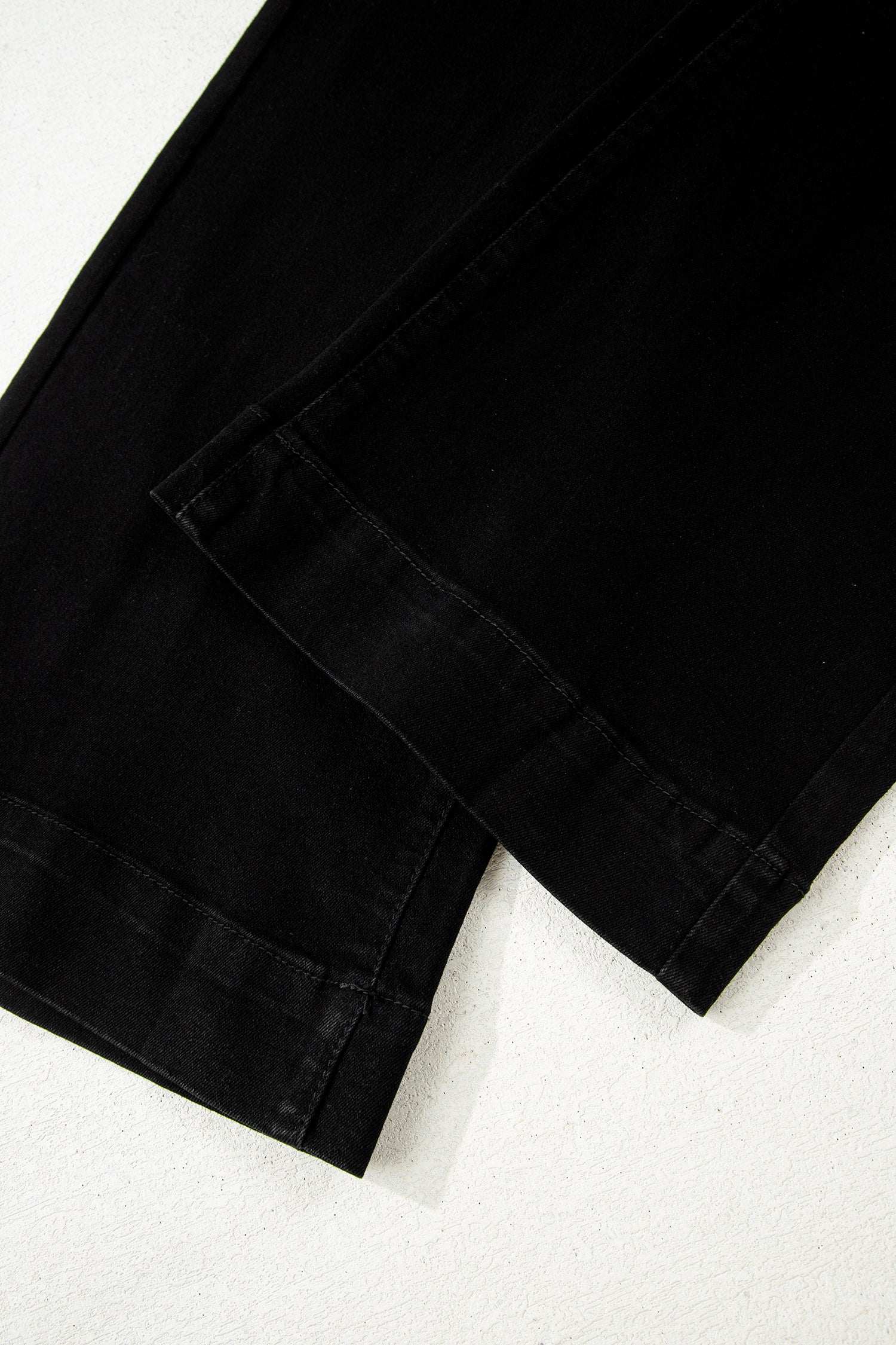 Black high rise wide leg jeans with double-button waistband, front pockets and cropped hem.