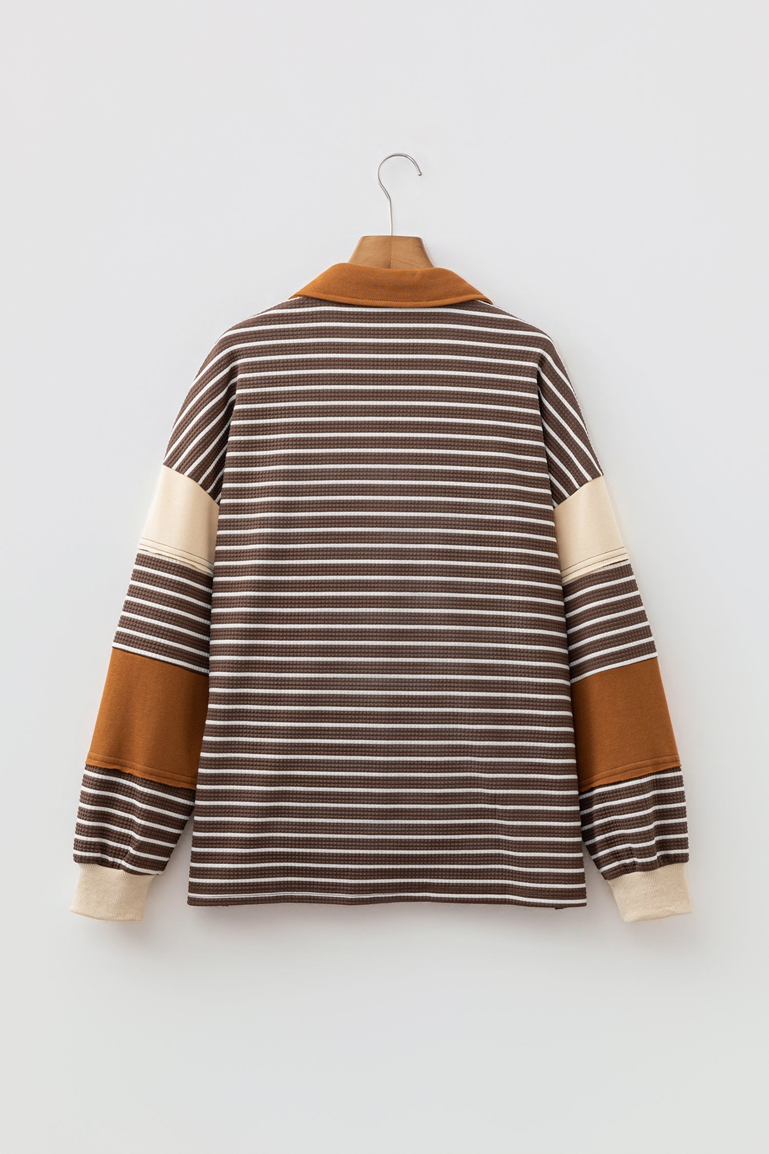 Cocoa Caramel and ivory striped colorblock pullover with a collared V-neckline, dropped shoulders, and long paneled sleeves.