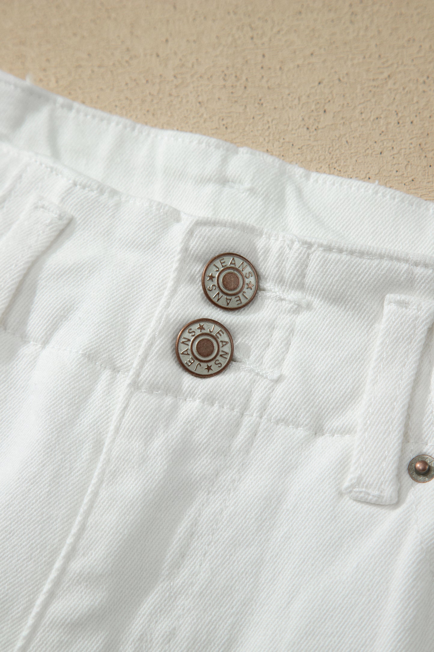 White high rise wide leg jeans with double-button waistband, front pockets and cropped hem.