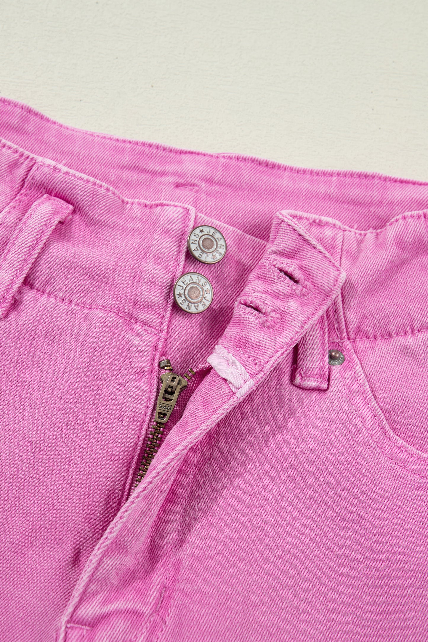 Pink high rise wide leg jeans with double-button waistband, front pockets and cropped hem.