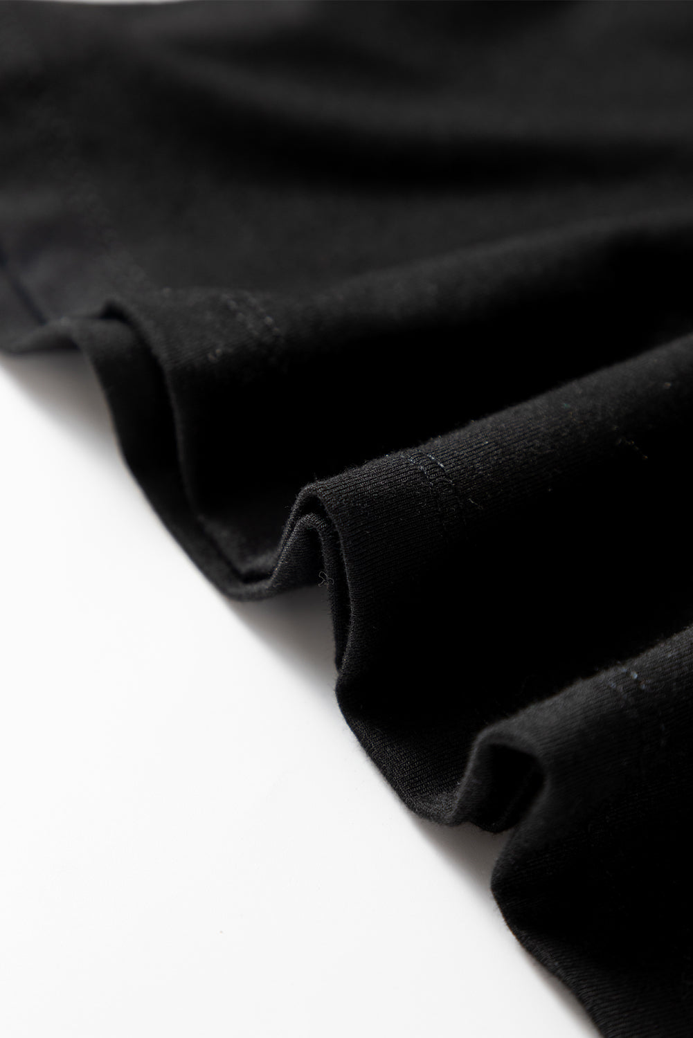 Woman wearing a Classic Black scoop neck long sleeve top with a soft casual fit and white pants.