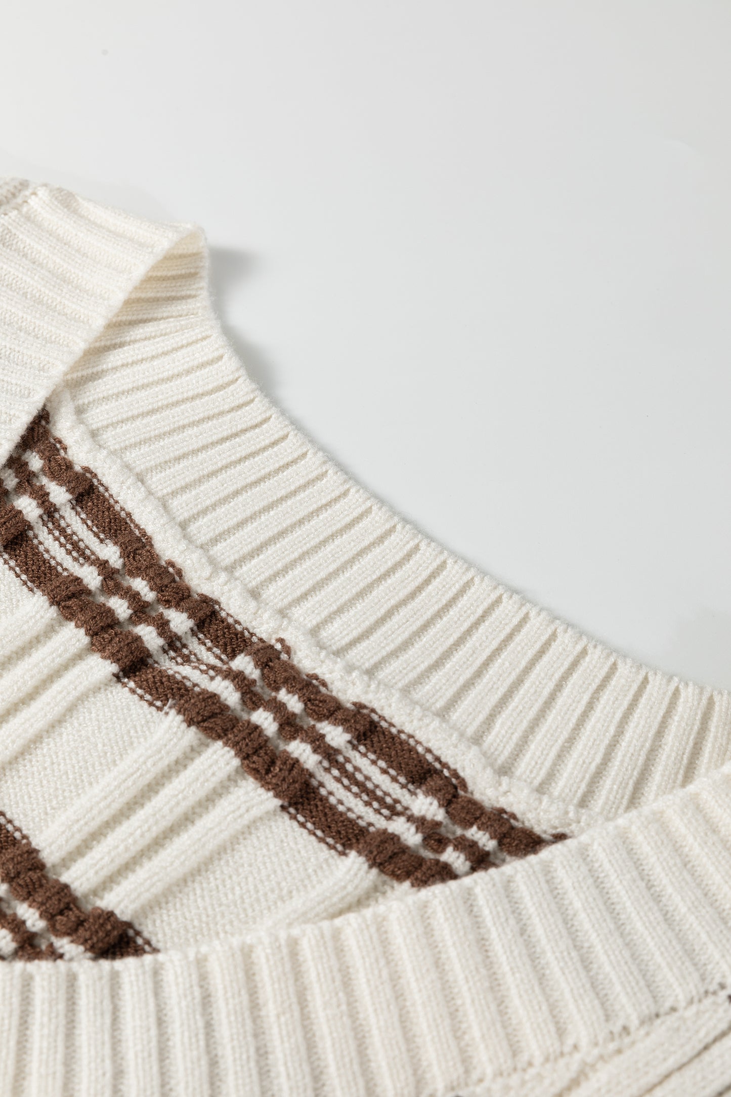 Oatmeal knit sweater vest with brown striped pattern, V-neckline, sleeveless design, and ribbed trim.