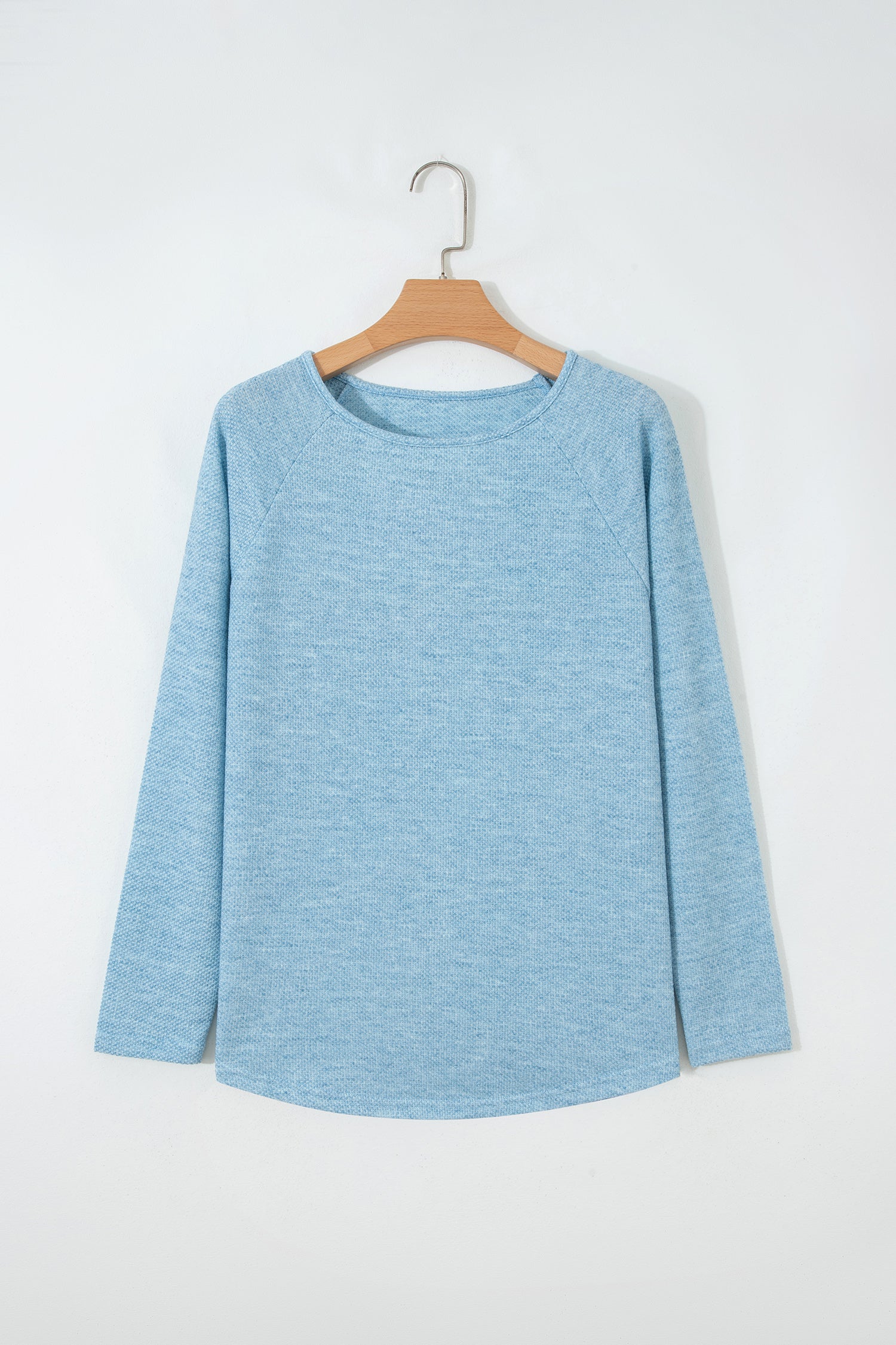 Powder Blue textured raglan long sleeve top with round neckline, relaxed fit, and curved hem