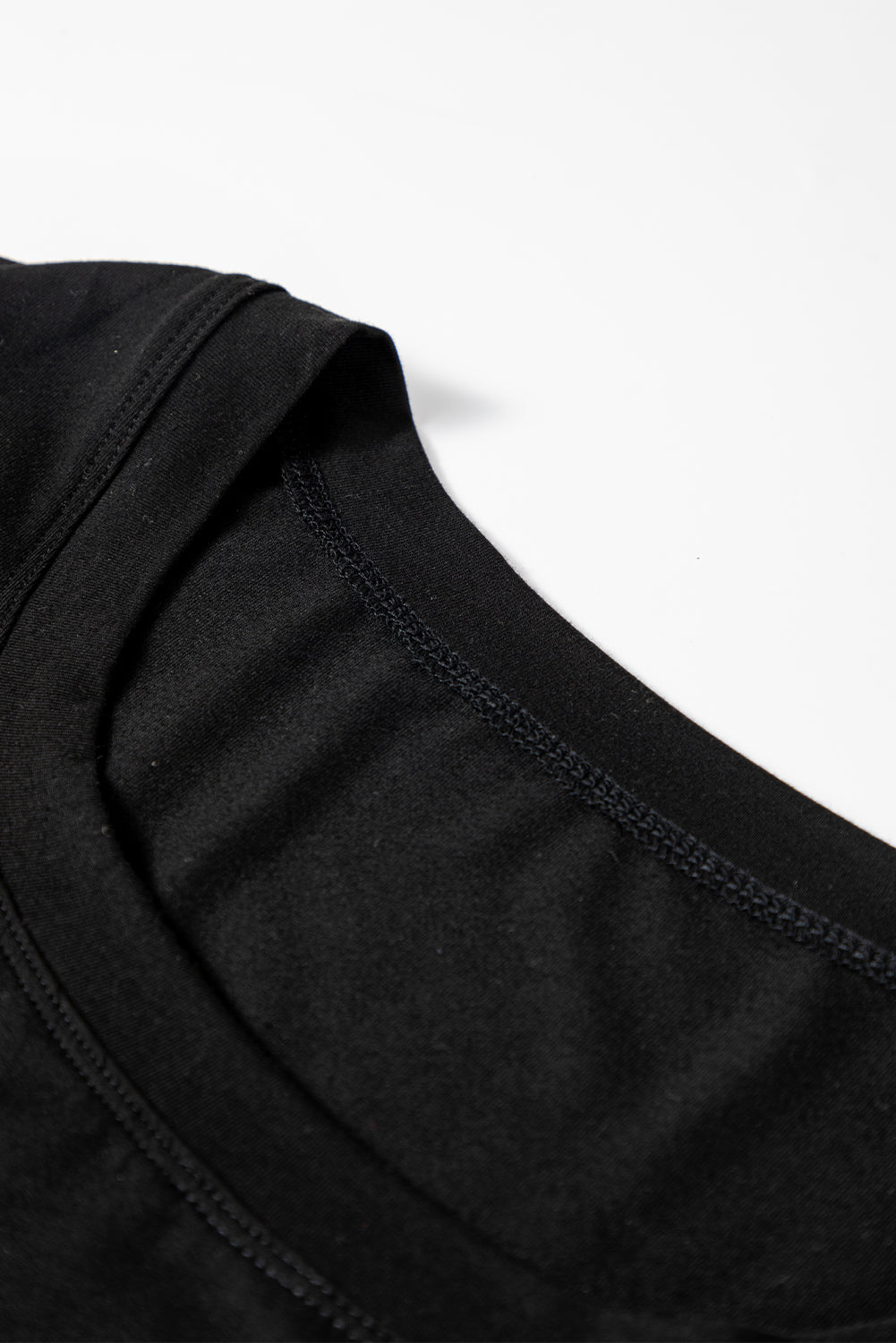 Woman wearing a Classic Black scoop neck long sleeve top with a soft casual fit and white pants.