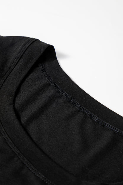 Woman wearing a Classic Black scoop neck long sleeve top with a soft casual fit and white pants.