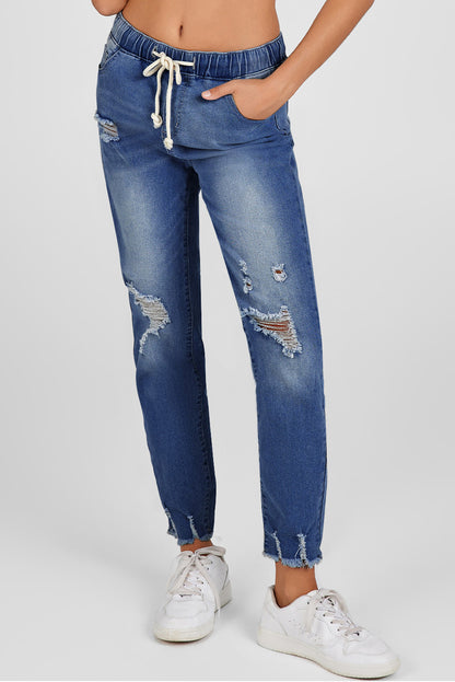 Medium wash blue distressed slim straight leg jeans with drawstring elastic waist and raw hem