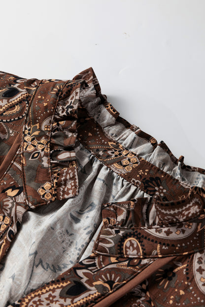 Mocha paisley babydoll mini dress with V-neckline, tie detail, long gathered sleeves, and relaxed tiered silhouette.