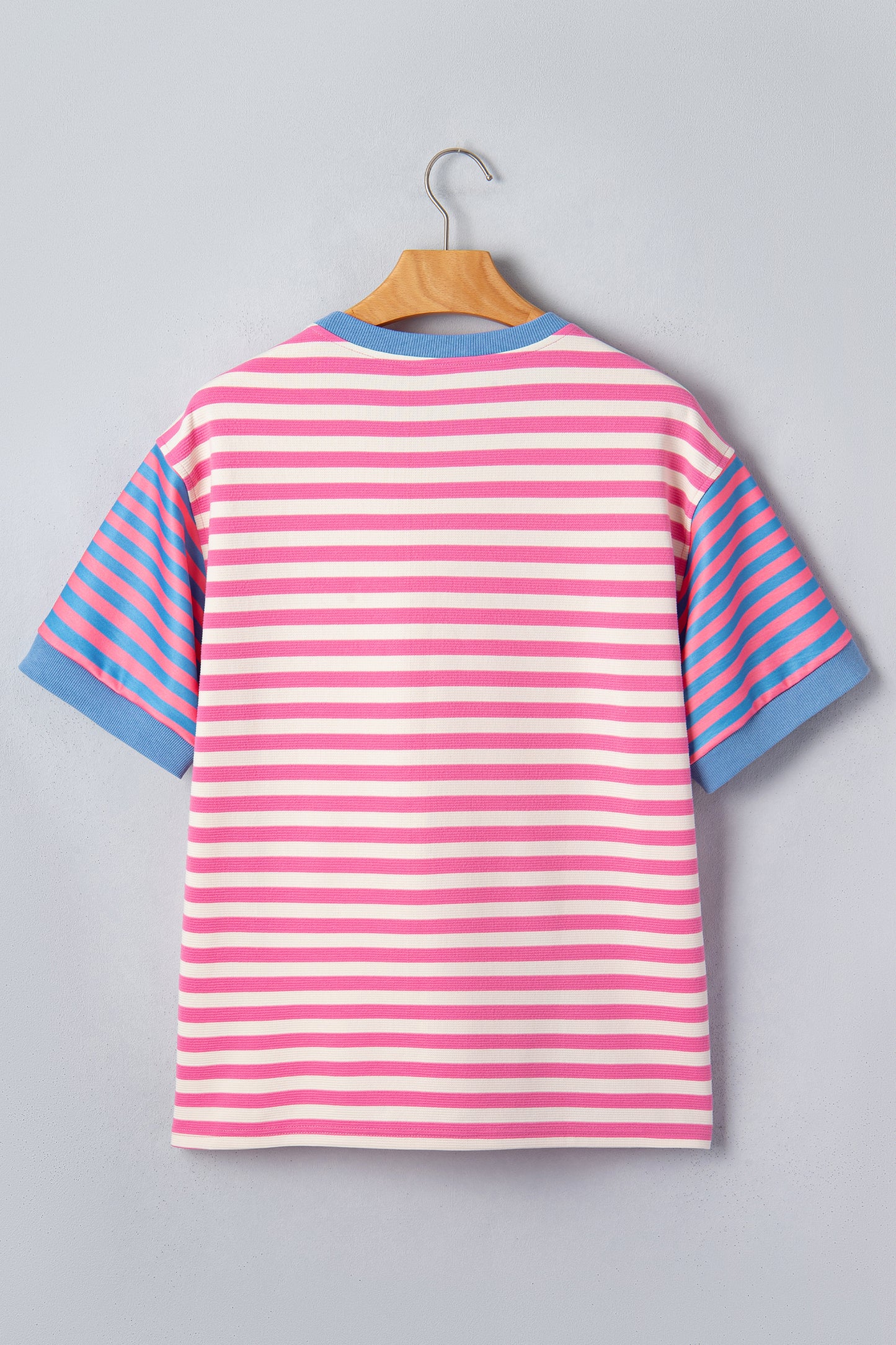 Pink and white textured striped knit short sleeve top with blue contrast ribbed neckline and sleeve cuffs, relaxed fit, and crew neckline.