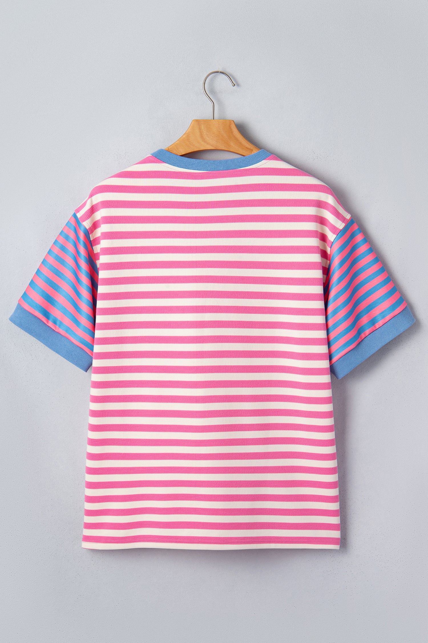 Pink and white textured striped knit short sleeve top with blue contrast ribbed neckline and sleeve cuffs, relaxed fit, and crew neckline.