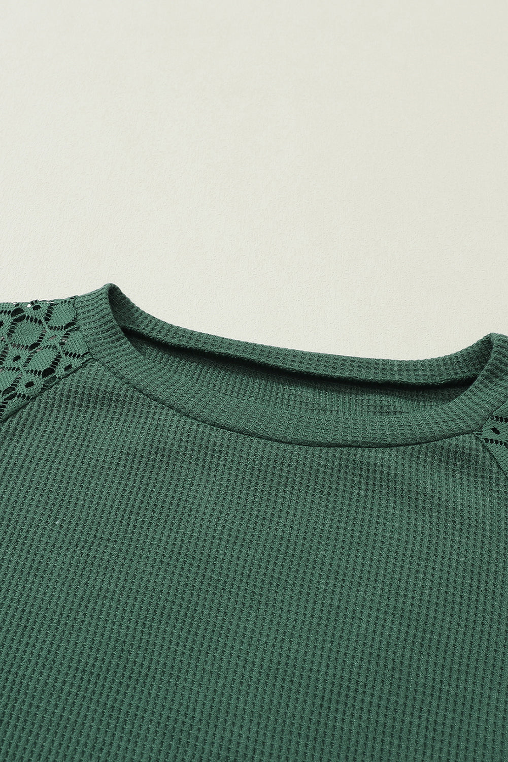 Forest green waffle knit long sleeve top with floral lace shoulder panels, crew neckline, relaxed fit, and balloon sleeves.