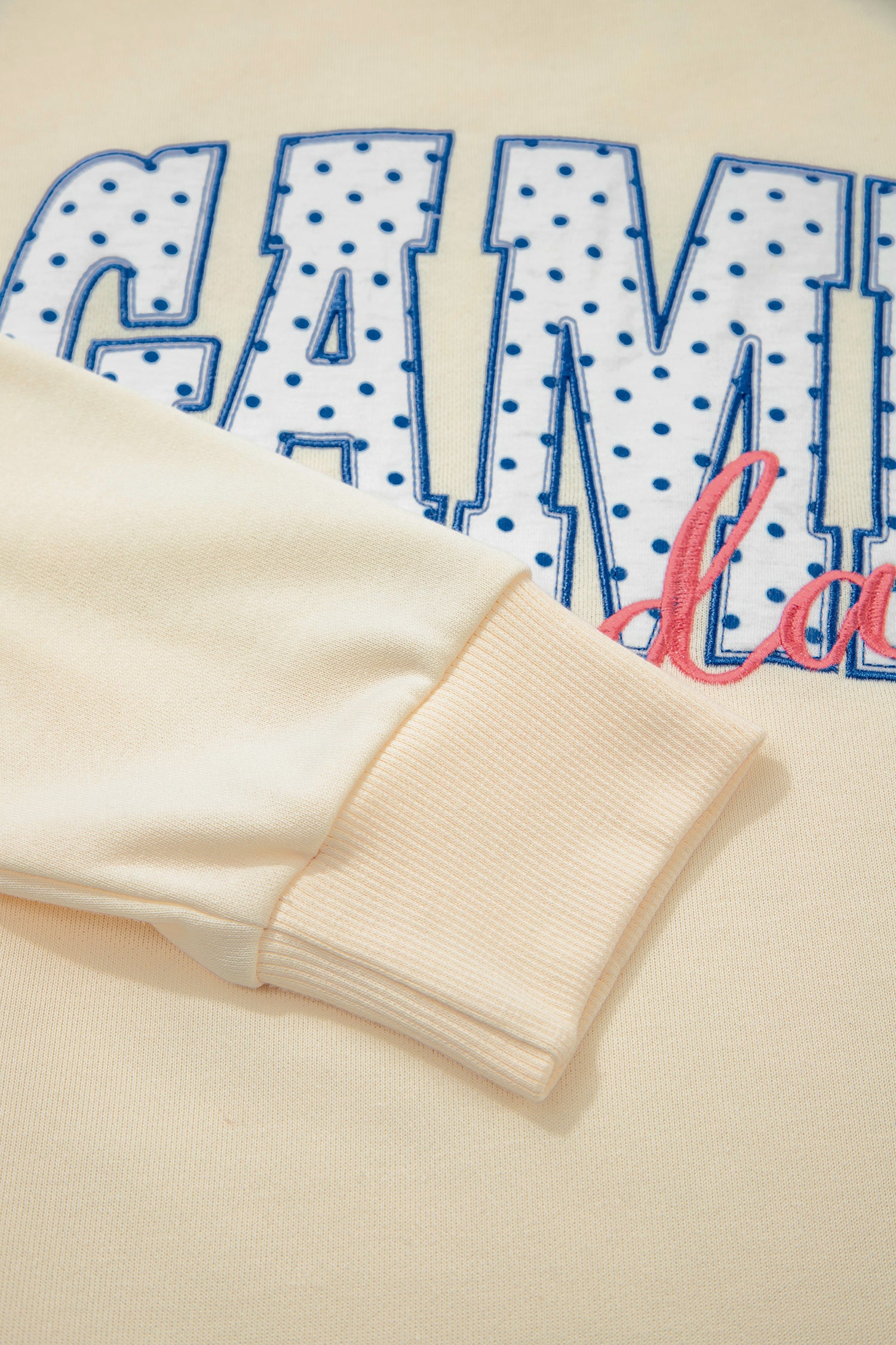 Cream Game Day embroidered sweatshirt and matching drawstring shorts set featuring long sleeves, blue contrast trim, relaxed fit, and casual sporty style.