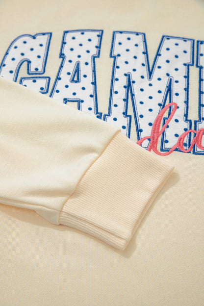 Cream Game Day embroidered sweatshirt and matching drawstring shorts set featuring long sleeves, blue contrast trim, relaxed fit, and casual sporty style.