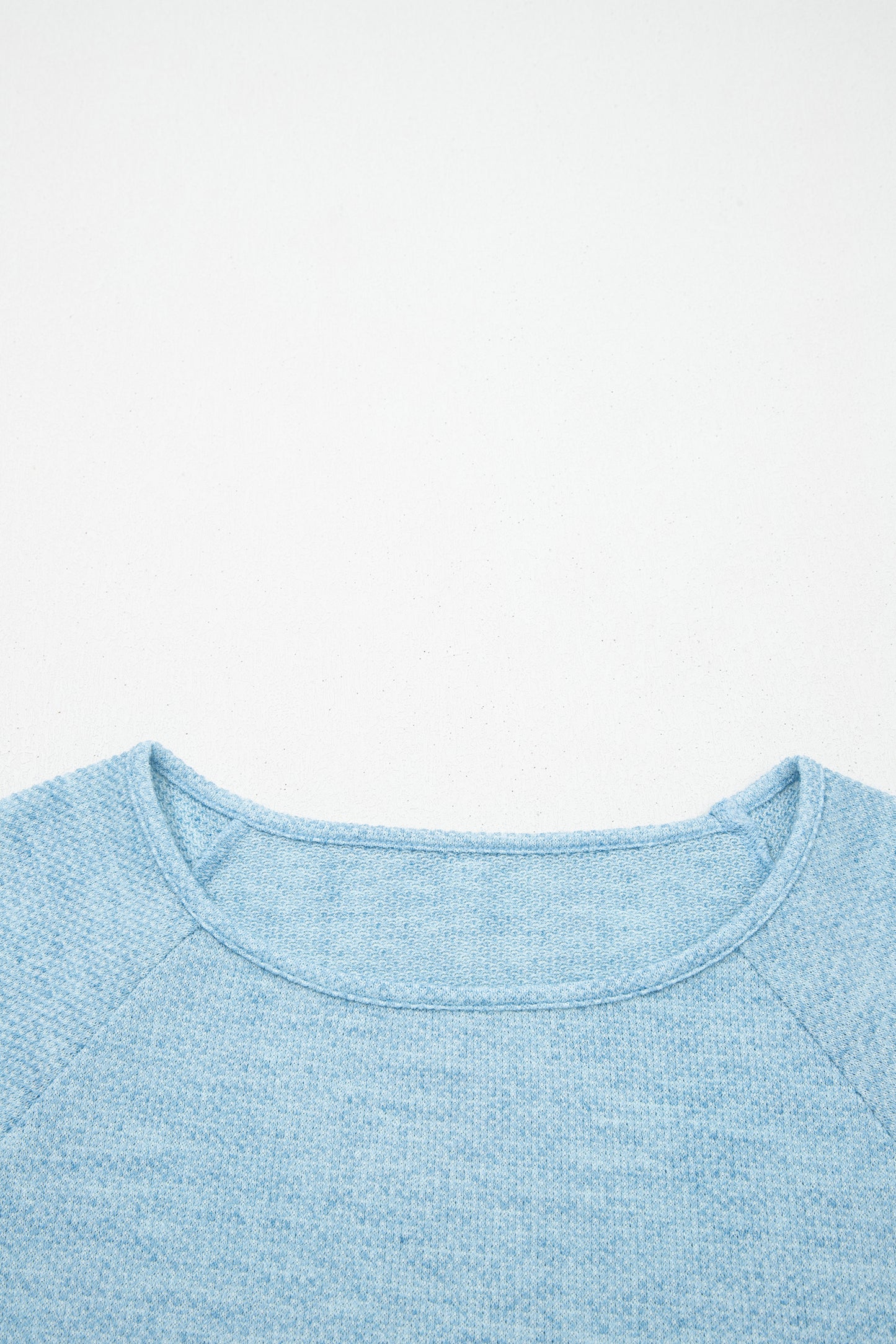 Powder Blue textured raglan long sleeve top with round neckline, relaxed fit, and curved hem
