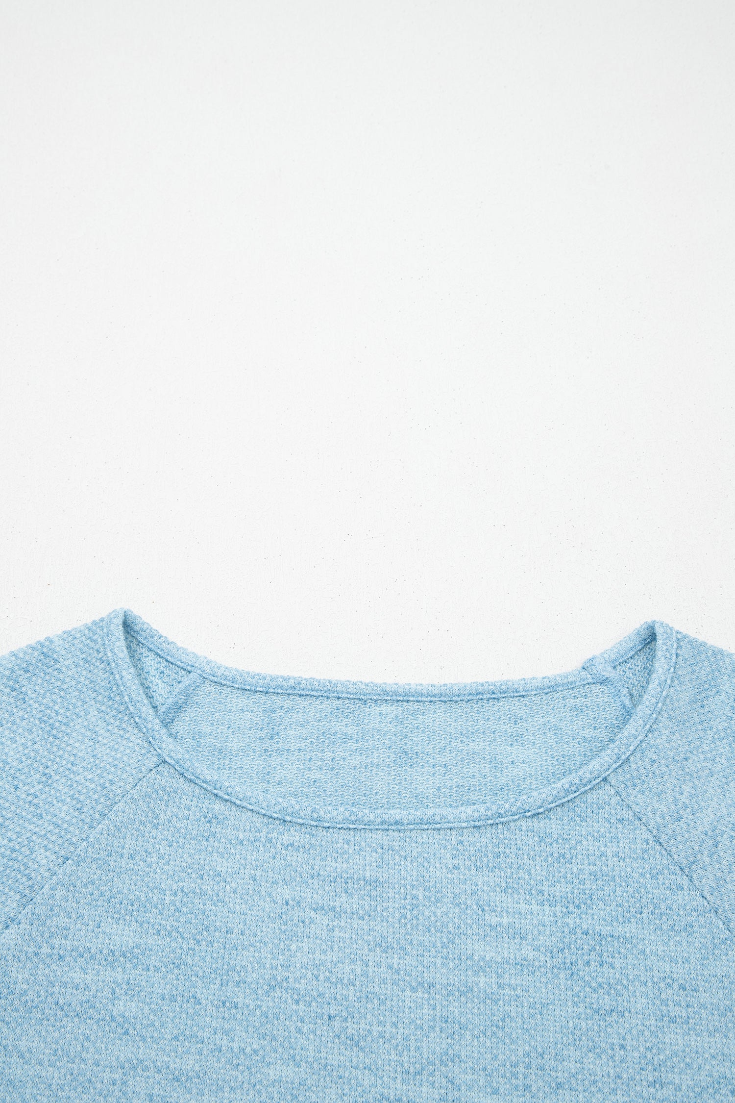 Powder Blue textured raglan long sleeve top with round neckline, relaxed fit, and curved hem