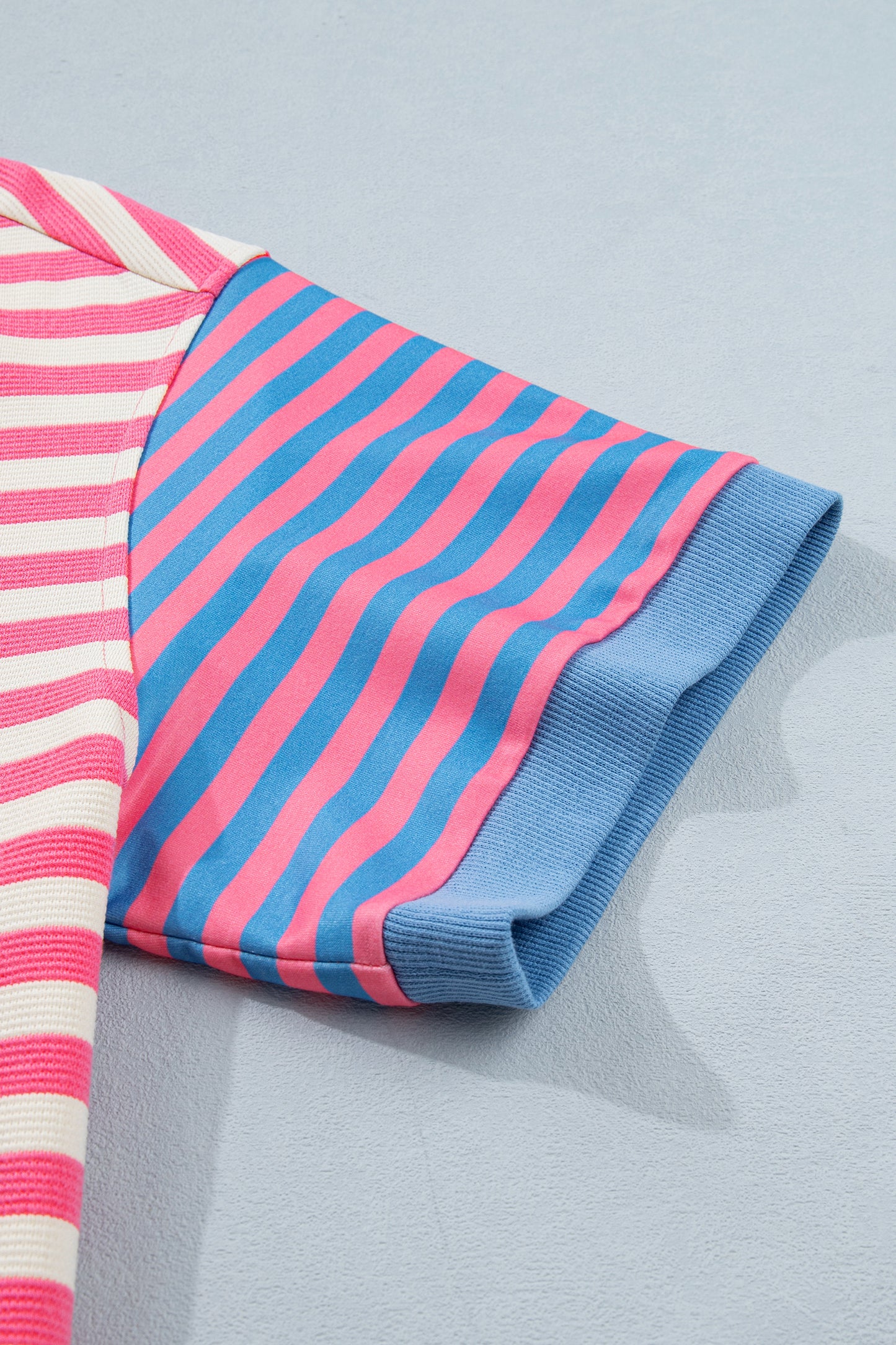 Pink and white textured striped knit short sleeve top with blue contrast ribbed neckline and sleeve cuffs, relaxed fit, and crew neckline.