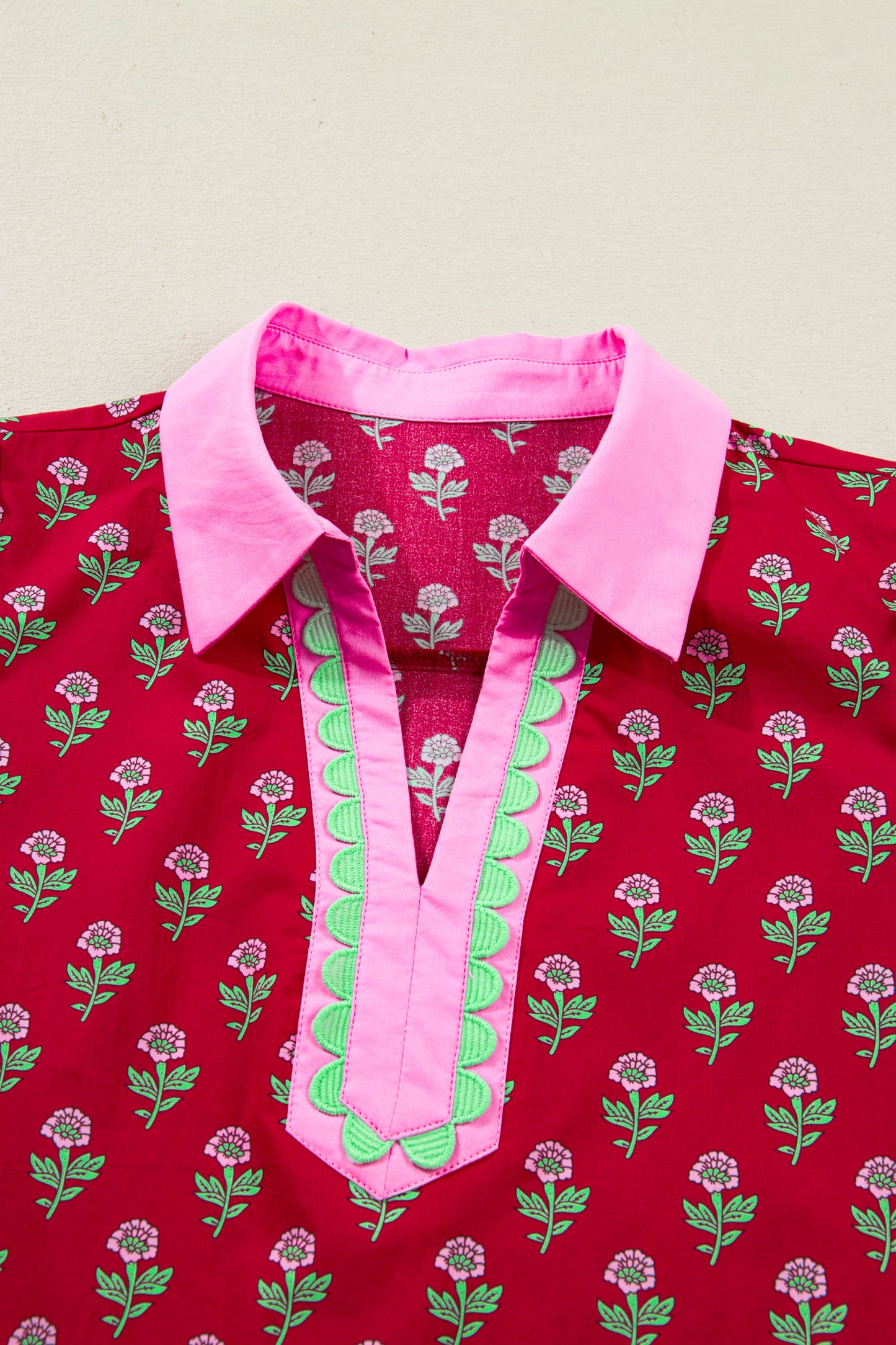 Red floral mini dress with pink collared neckline, mint scalloped trim, short puff sleeves, and a ruffled drop-waist hem