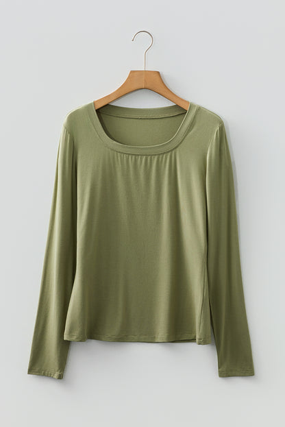 Woman wearing a Soft Sage scoop neck long sleeve top with a soft casual fit and white pants.