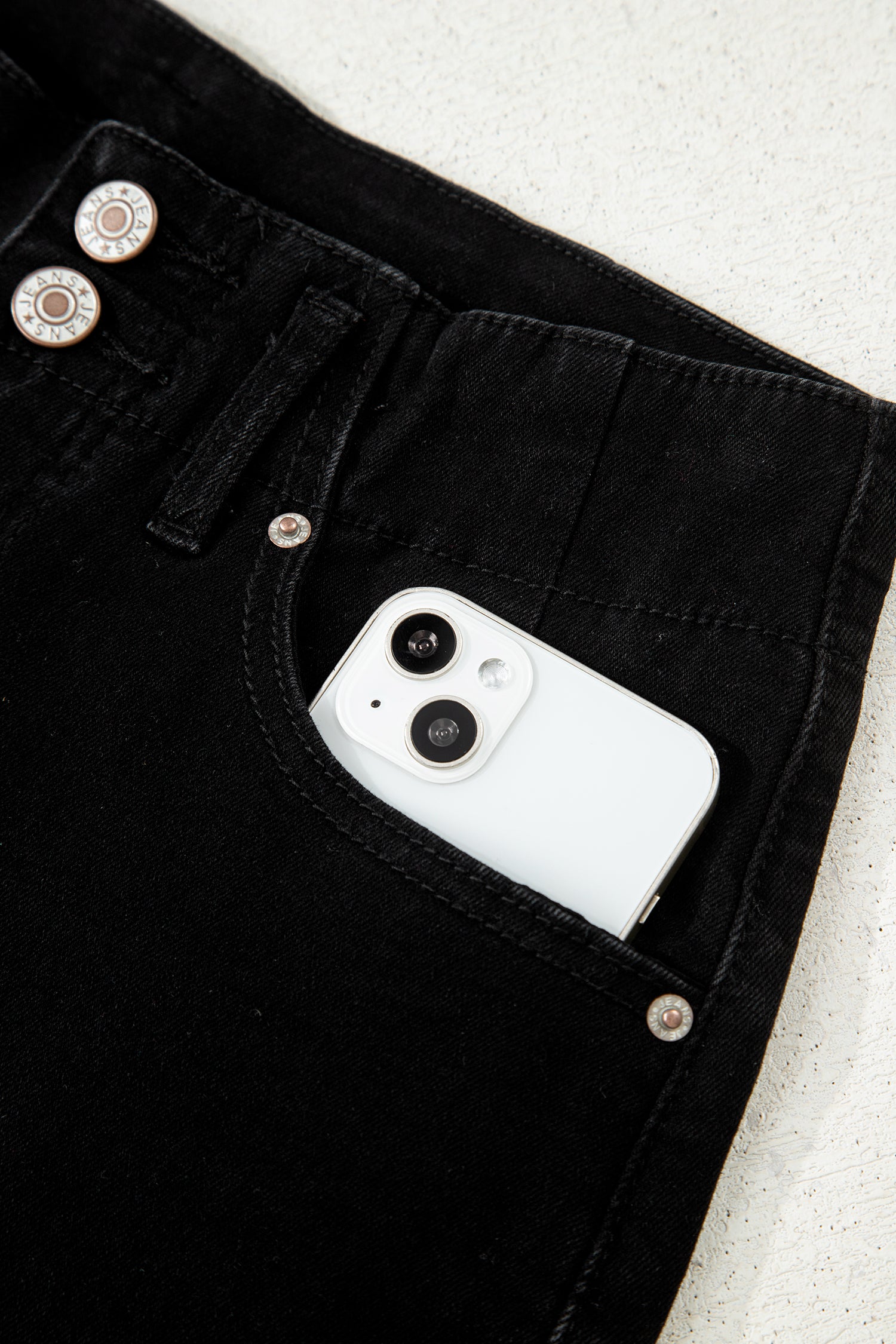 Black high rise wide leg jeans with double-button waistband, front pockets and cropped hem.